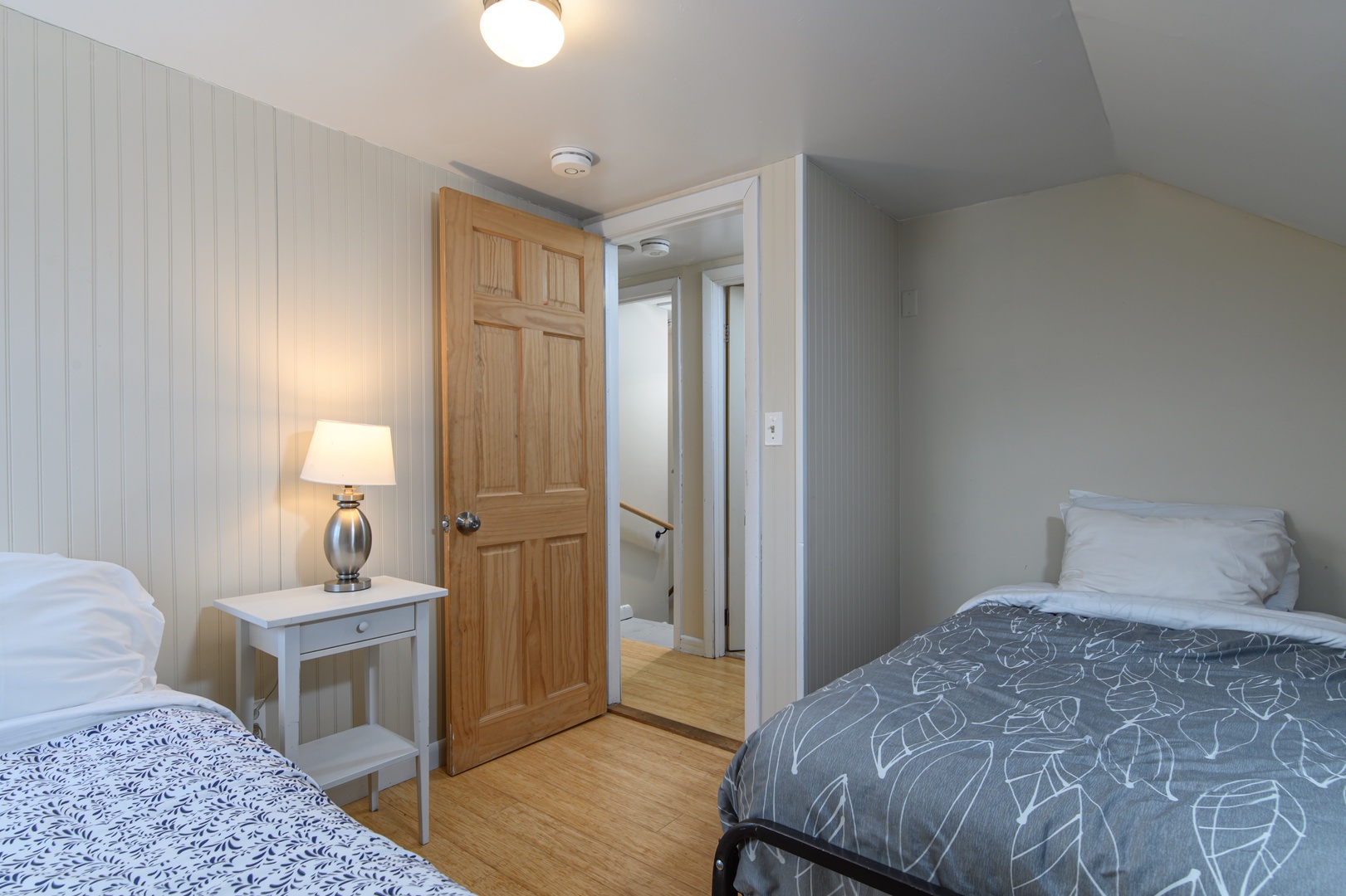 A bright and kid-friendly upstairs bedroom with two twin beds, designed for easy bedtime routines, sleepovers, and cozy downtime.