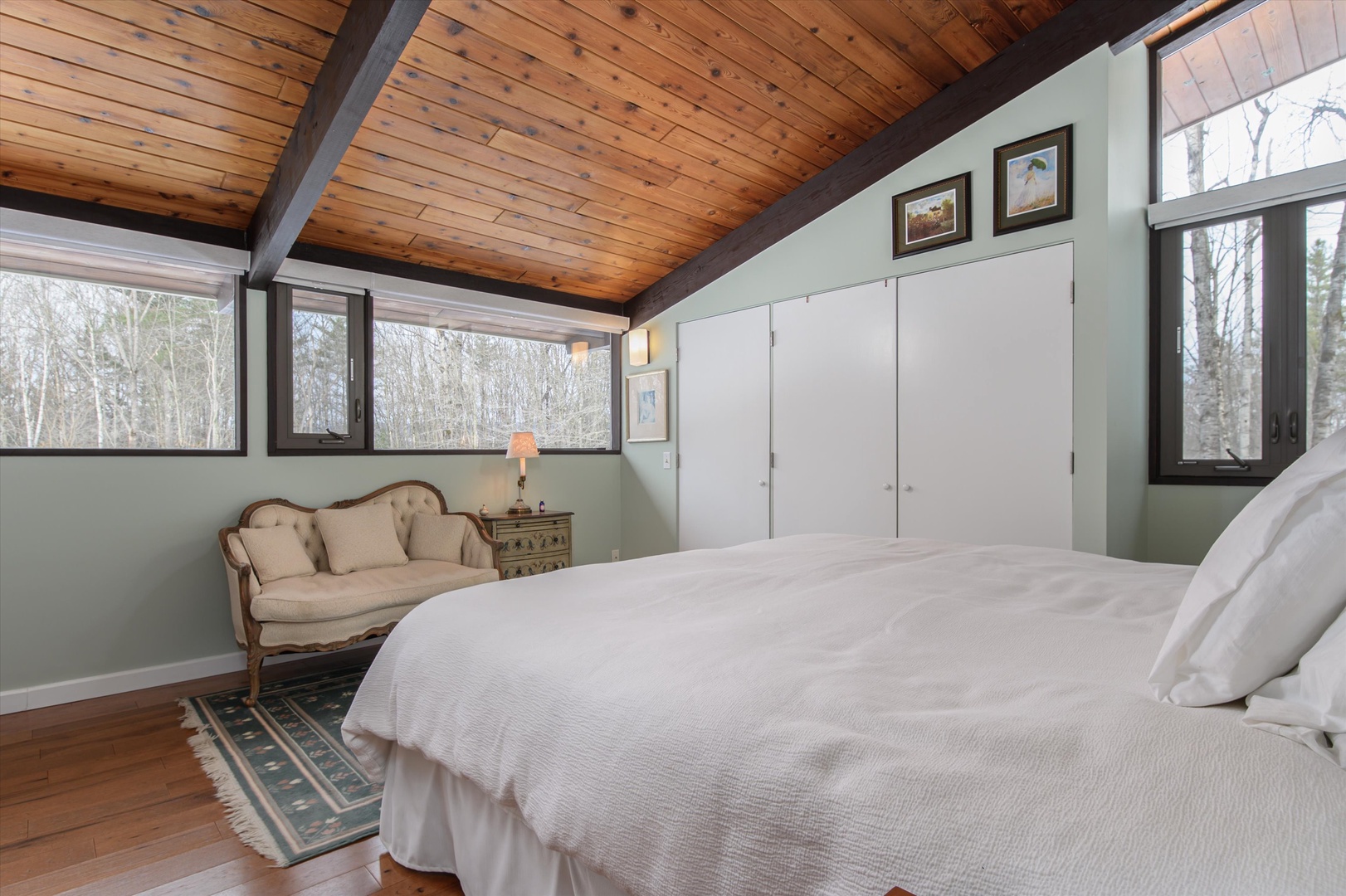 Peaceful Primary King bedroom sanctuary features rustic wood beams overhead and crisp linens