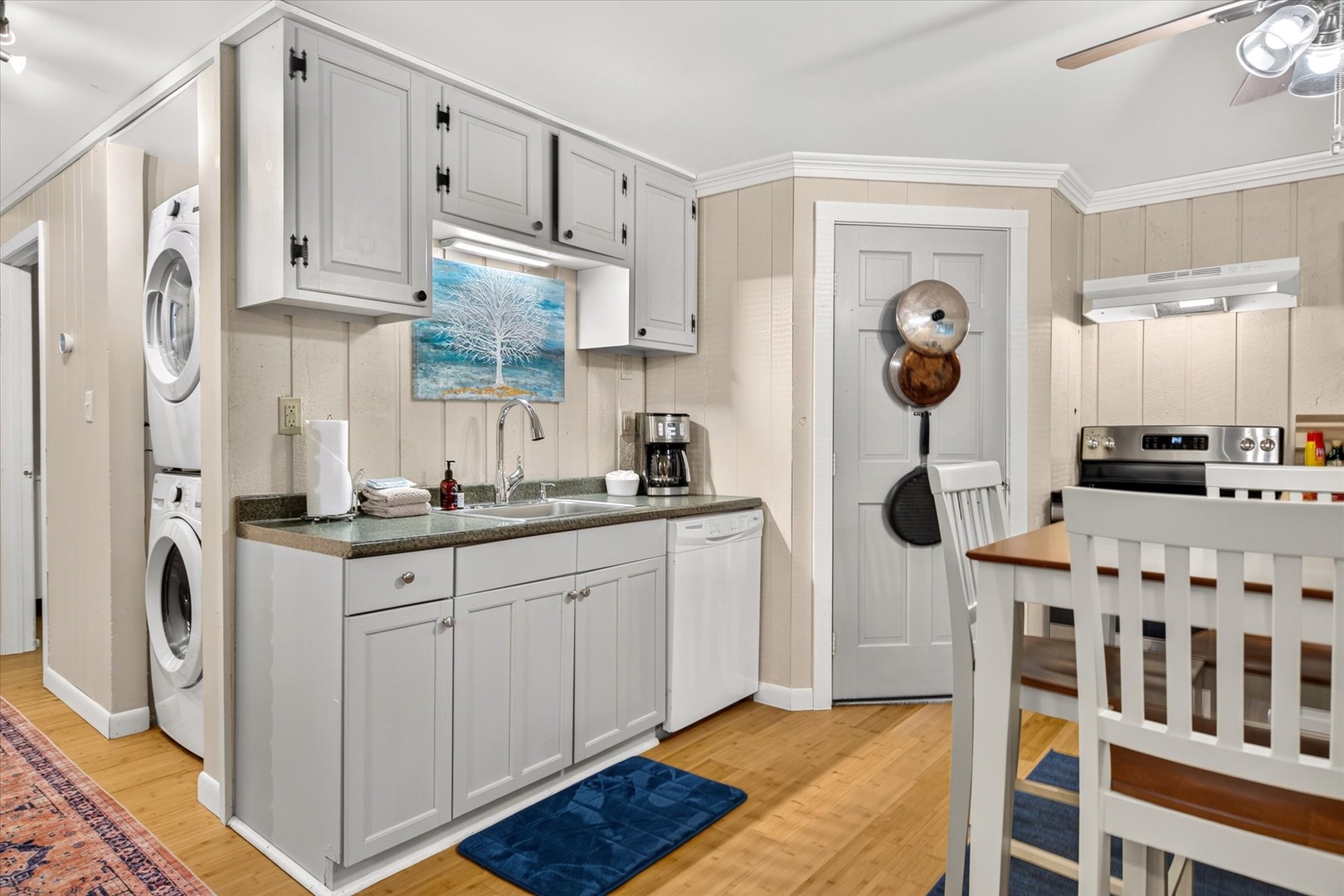 Your kitchen and dining area blend convenience with coastal charm—crisp white cabinetry, warm wood floors, and cheerful touches make cooking and gathering a breeze.