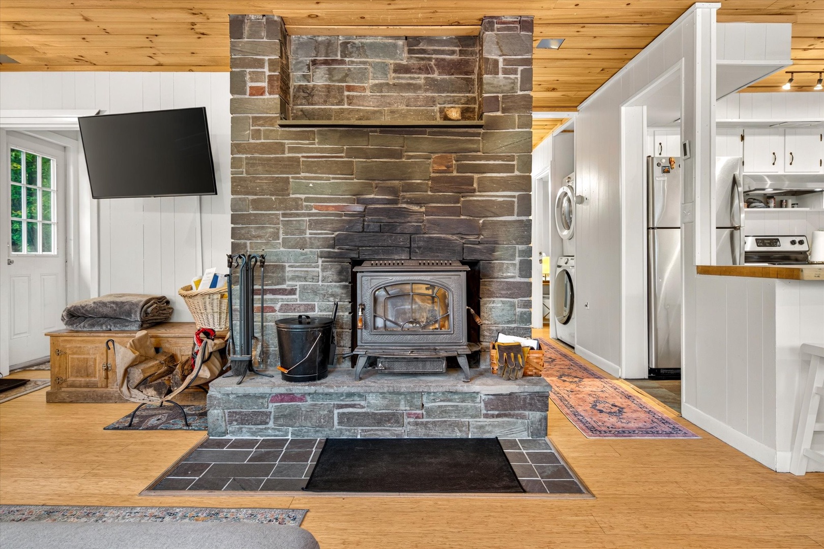 Gather by the warmth of your classic wood-burning stove, framed by rustic stonework that reaches to wooden cathedral ceilings—a cozy retreat where mountain charm meets modern convenience.