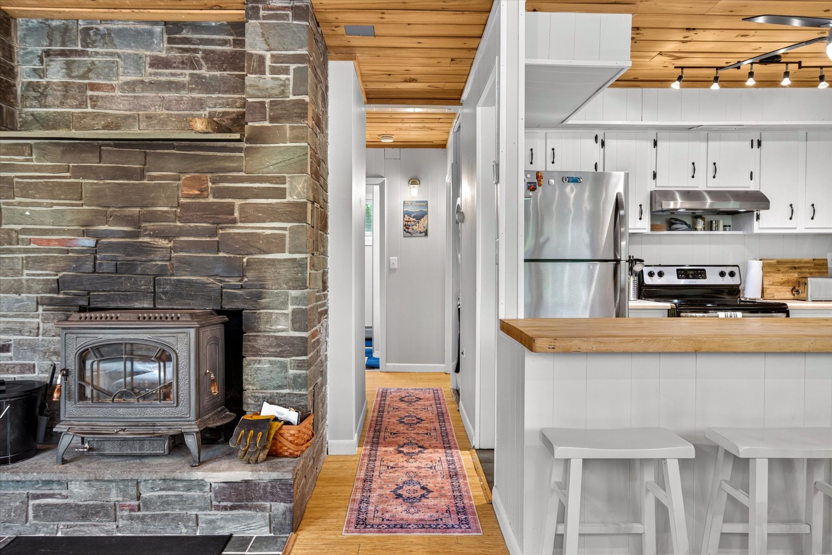Warm wood tones and rustic brick complement your modern kitchen. The wood-burning stove adds character and cozy warmth, making this space perfect for relaxing evenings after mountain adventures.