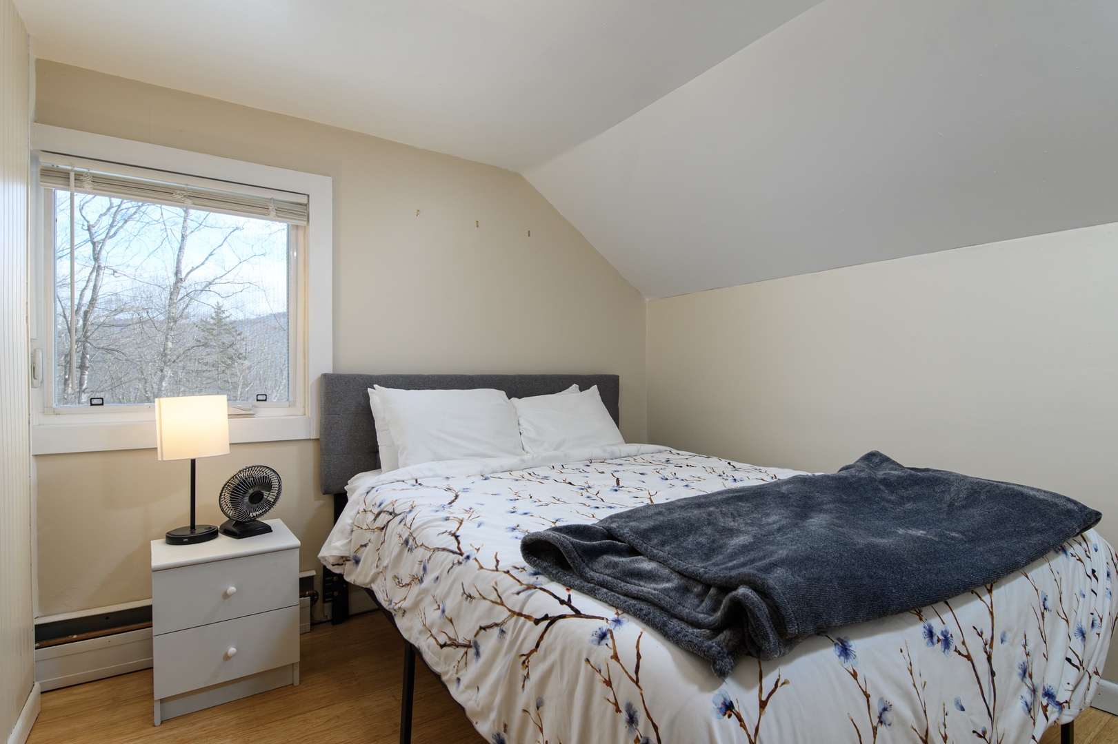 A comfortable upstairs bedroom with a queen bed, offering a quiet and relaxing space to unwind and enjoy a restful night’s sleep.