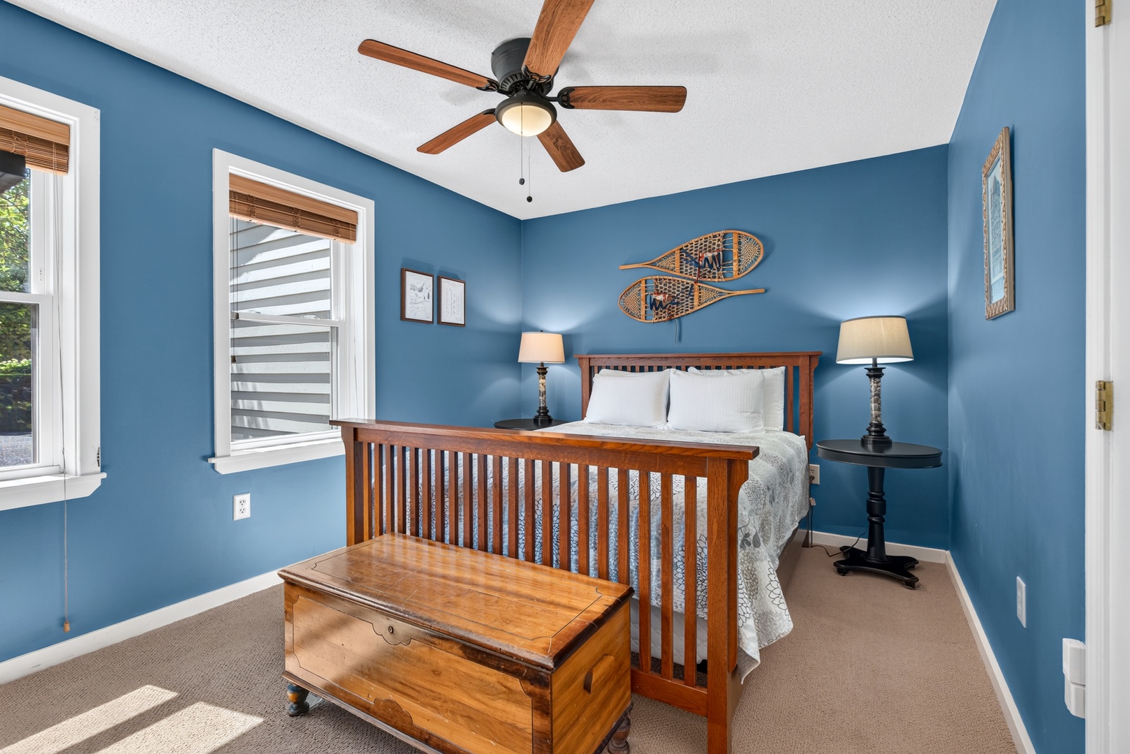 Sink into your cozy bed in this tranquil blue retreat, where warm wood tones and soft lighting create the perfect atmosphere for rest and relaxation.