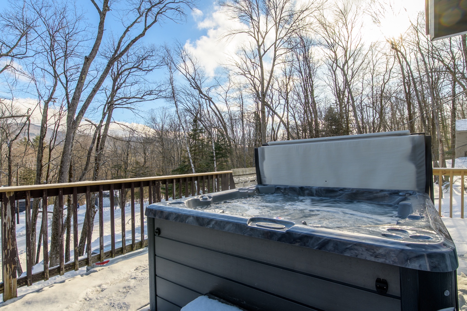 Soak in your private hot tub surrounded by snow-dusted trees and peaceful winter forest views.