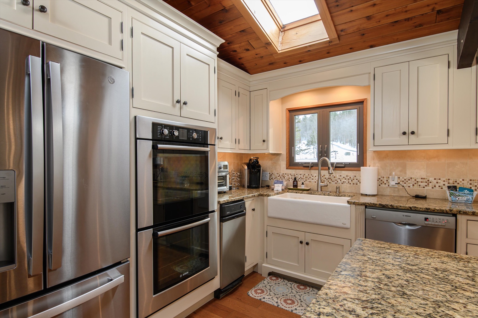 Your fully-equipped kitchen features granite countertops, stainless steel appliances, and a charming skylight that fills the space with natural light.