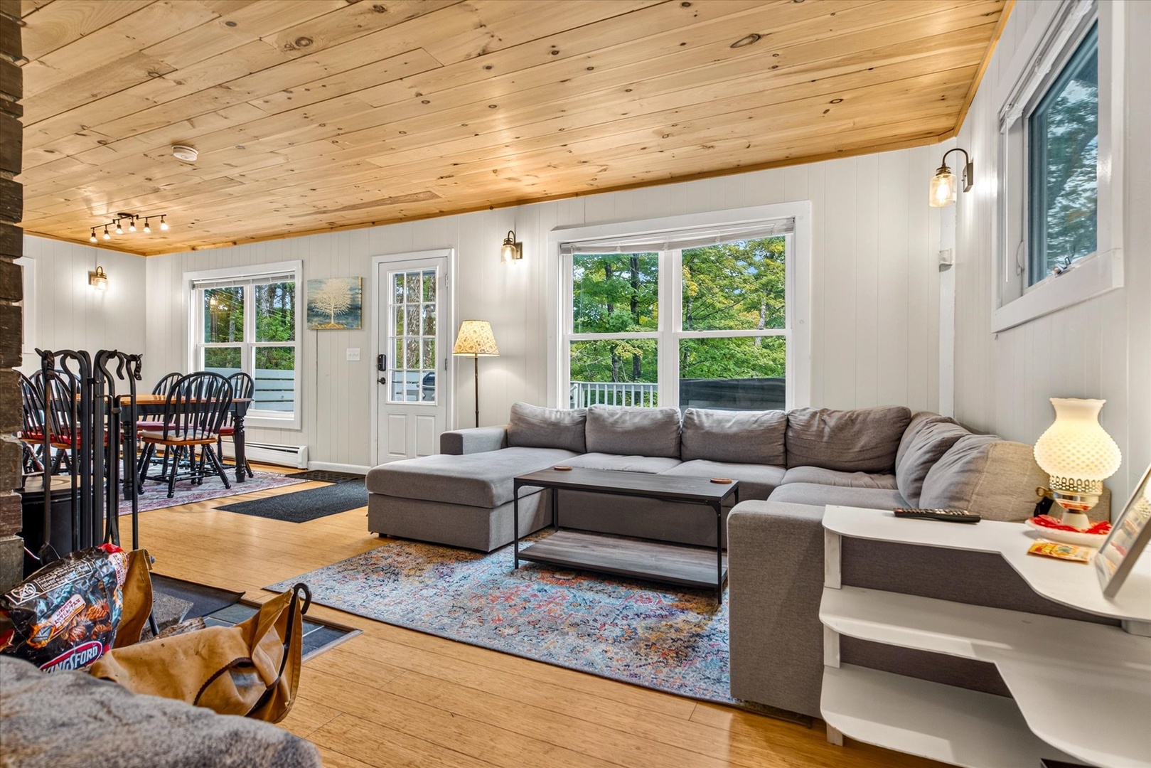 Sink into the plush sectional and unwind under the warmth of natural wood ceilings. Your open-concept retreat blends comfort and charm with abundant natural light and easy access to outdoor spaces.