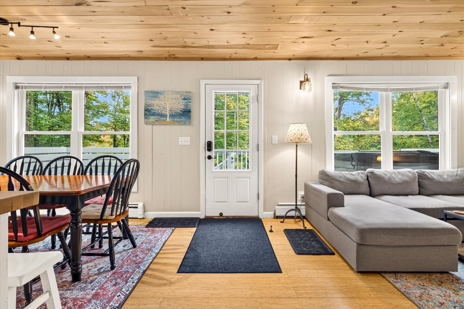 Cozy retreat flooded with natural light and forest views. Relax on the sectional or gather at the dining table beneath warm wood-beamed ceilings for rustic charm.