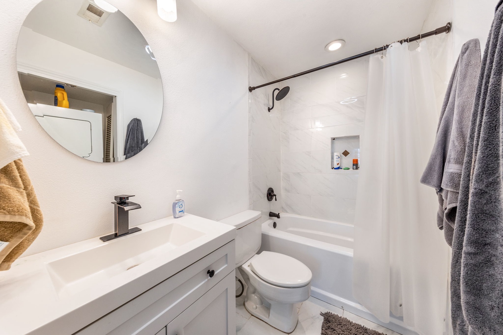 Refresh in this clean, modern bathroom with a bright tub-shower combo, stylish vanity, and soft towels ready for your stay.