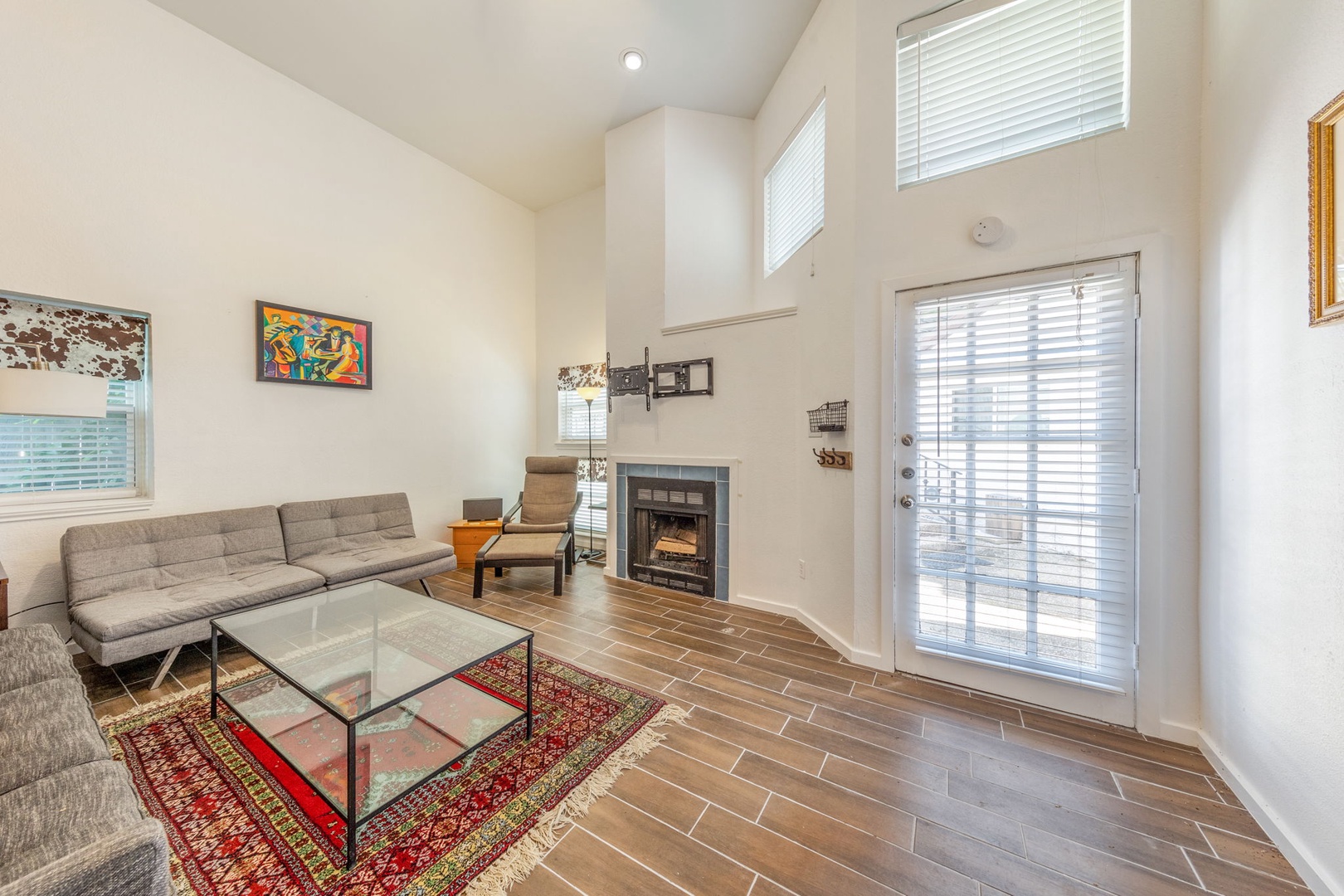 TV currently installed above fireplace not shown.  Unwind in your bright living room with vaulted ceilings, cozy fireplace, and comfortable seating—perfect for relaxing evenings after exploring the area.
