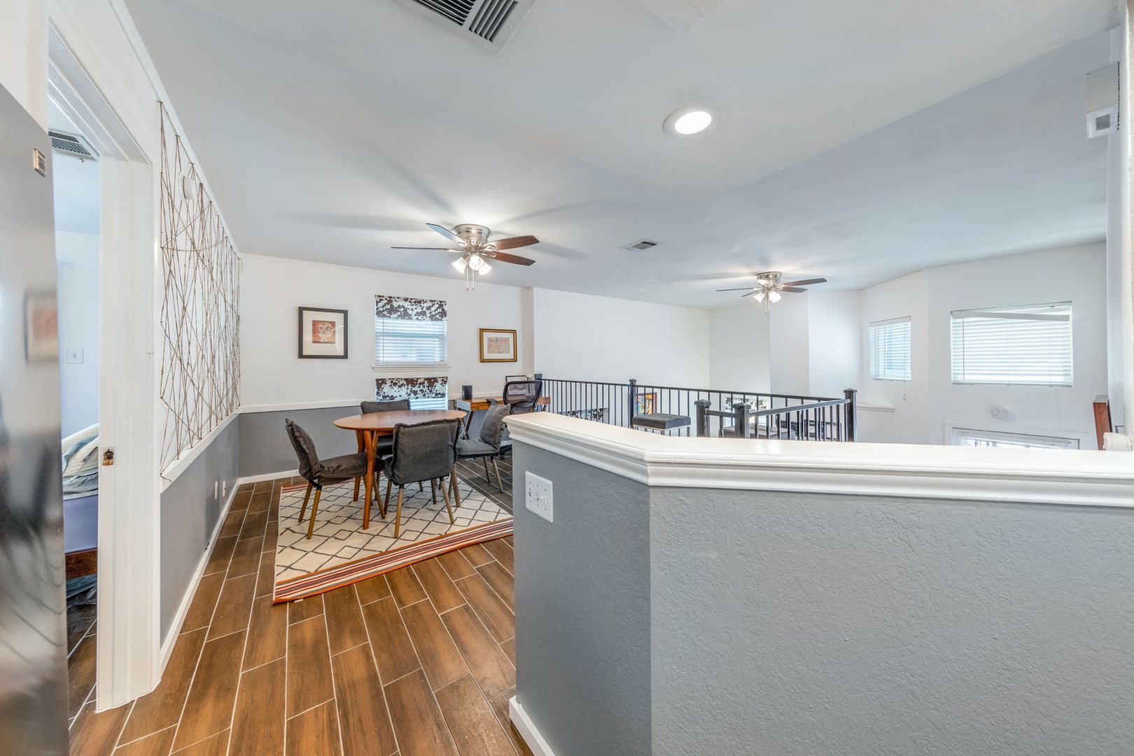 Bright upper-level loft with dining nook and tasteful two-tone walls creating a versatile gathering space for meals, work, or conversation.