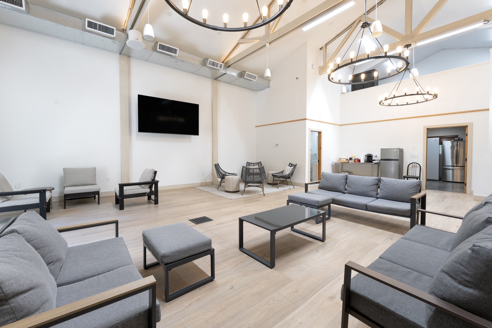 Gather with fellow travelers in this expansive communal lounge featuring soaring ceilings with natural wood beams, modern chandeliers, and cozy seating areas—your home base for relaxation and connection.