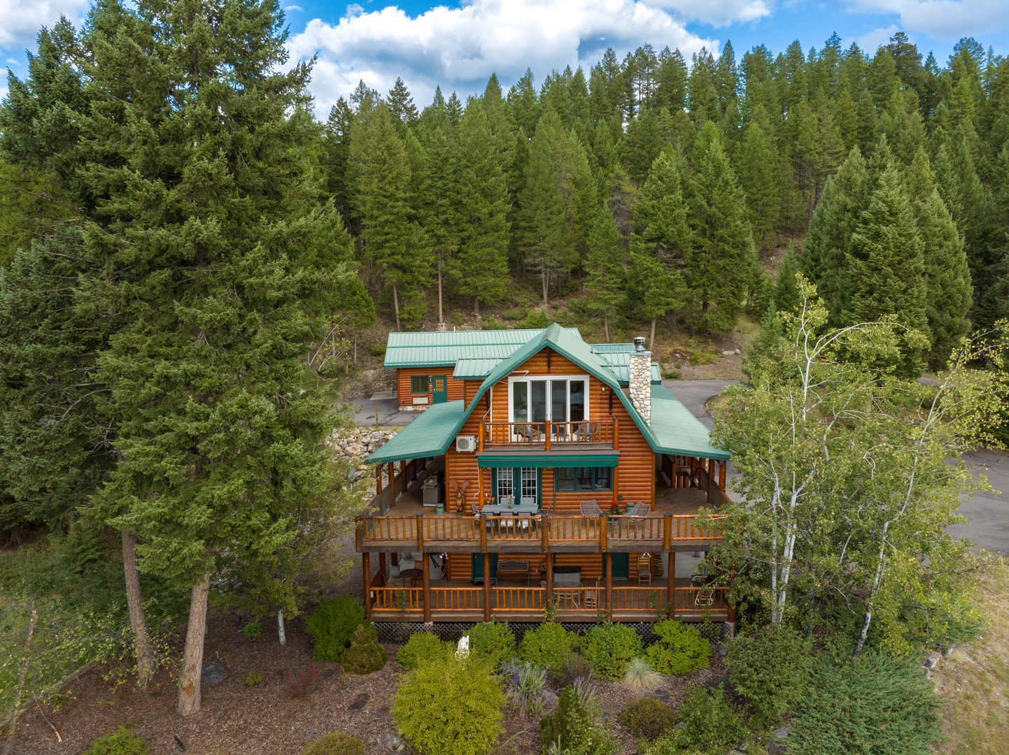 A secluded mountain cabin nestled among towering evergreens, offering a peaceful retreat surrounded by nature's beauty and privacy.