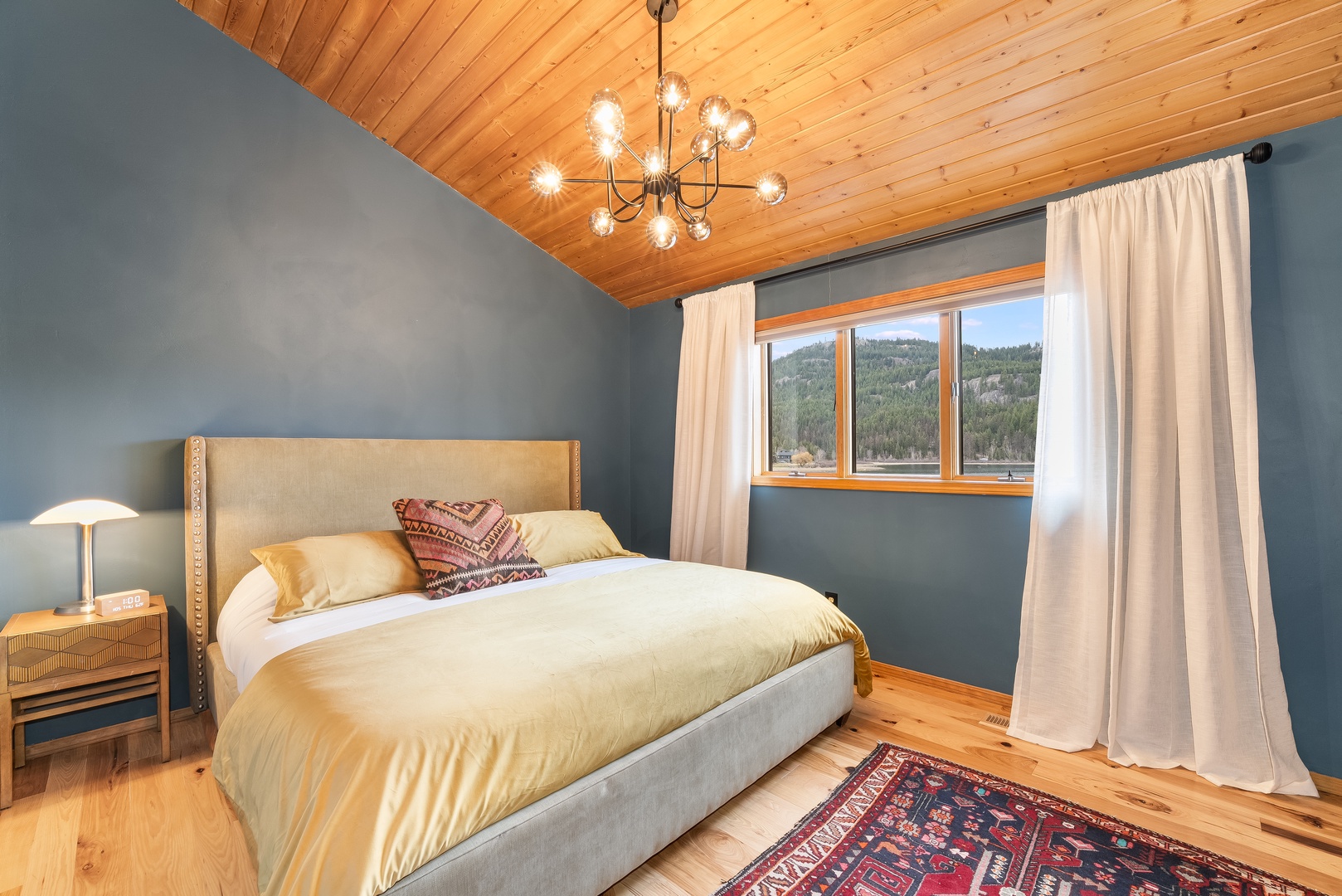 Drift off under warm wood beams and modern lighting, with peaceful mountain views framing your restful retreat.