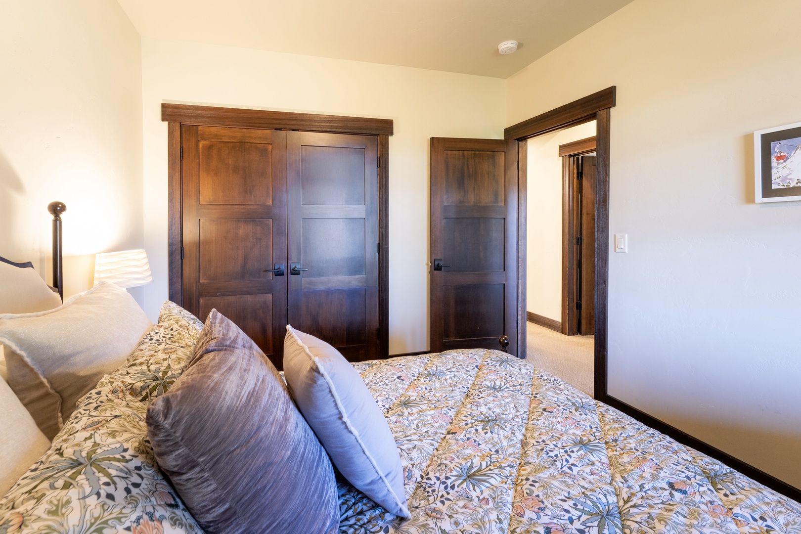Unwind in your cozy bedroom with a plush bed and elegant wood-paneled closets. The soft linens and warm, inviting tones make it a perfect retreat after a day of exploring.