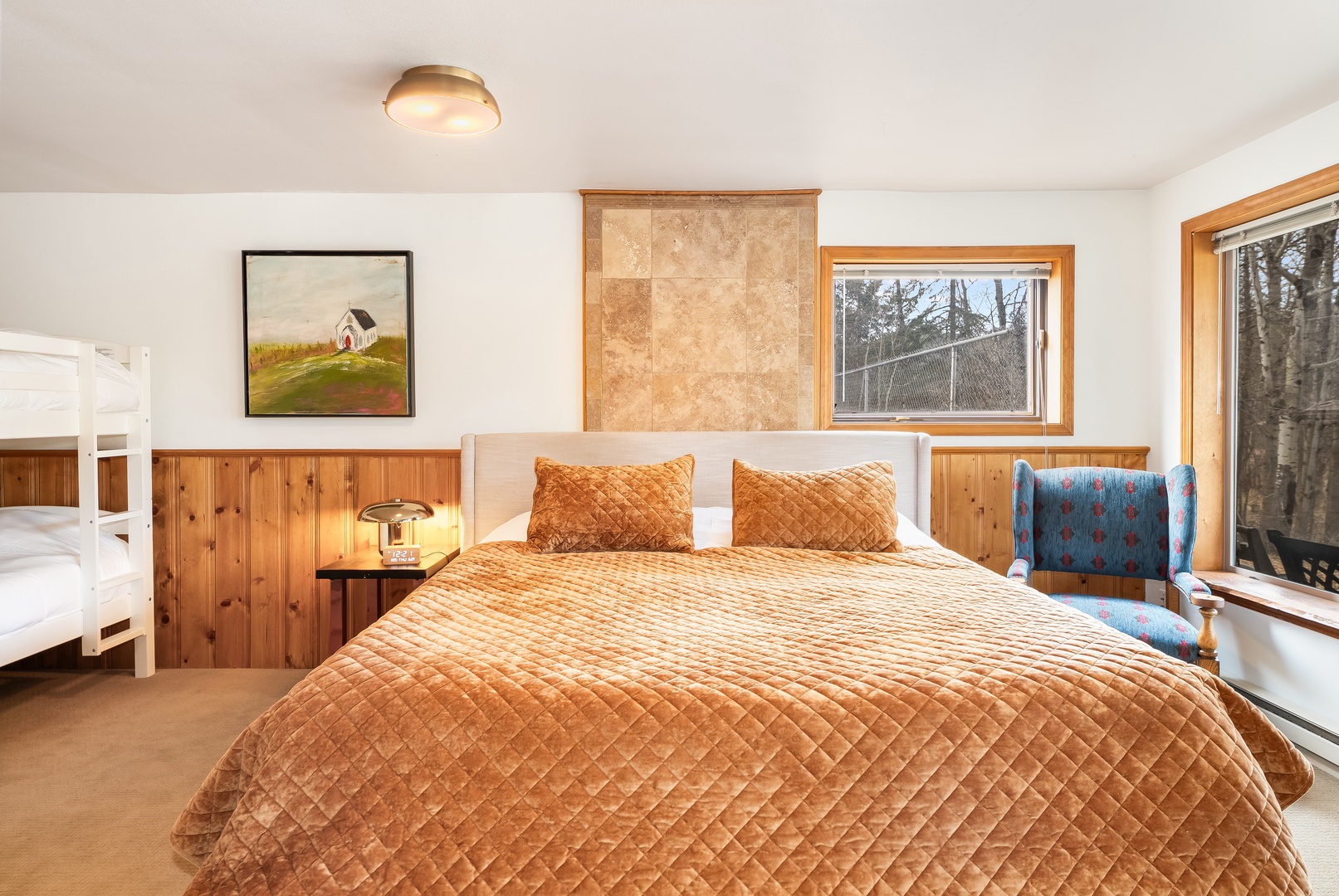 Sink into your plush quilted bed surrounded by warm wood accents and natural light streaming through forest views.