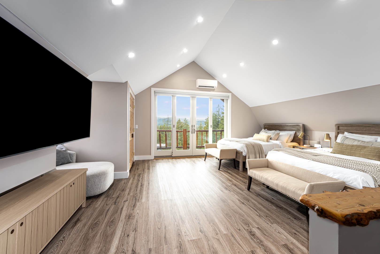 Unwind in your spacious retreat with vaulted ceilings, stylish wood-toned floors, plush beds, and a private balcony framing serene mountain views.