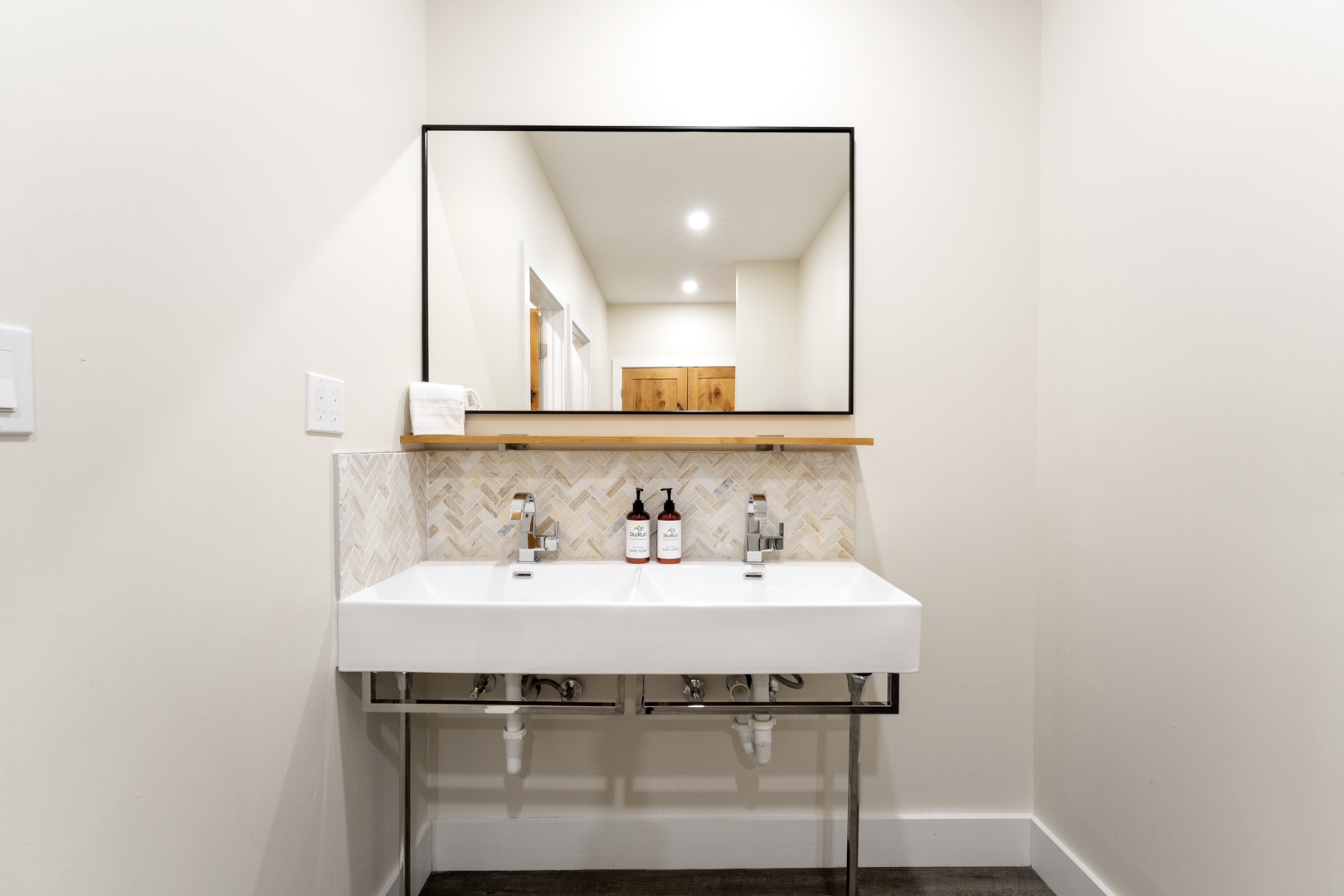 Refresh in your stylish double-sink vanity, where modern design meets boutique hotel charm with herringbone tile and premium fixtures.