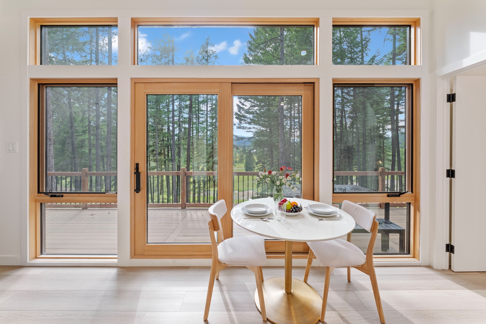 Enjoy breakfast at your cozy round table while soaking in stunning forest views through floor-to-ceiling windows.