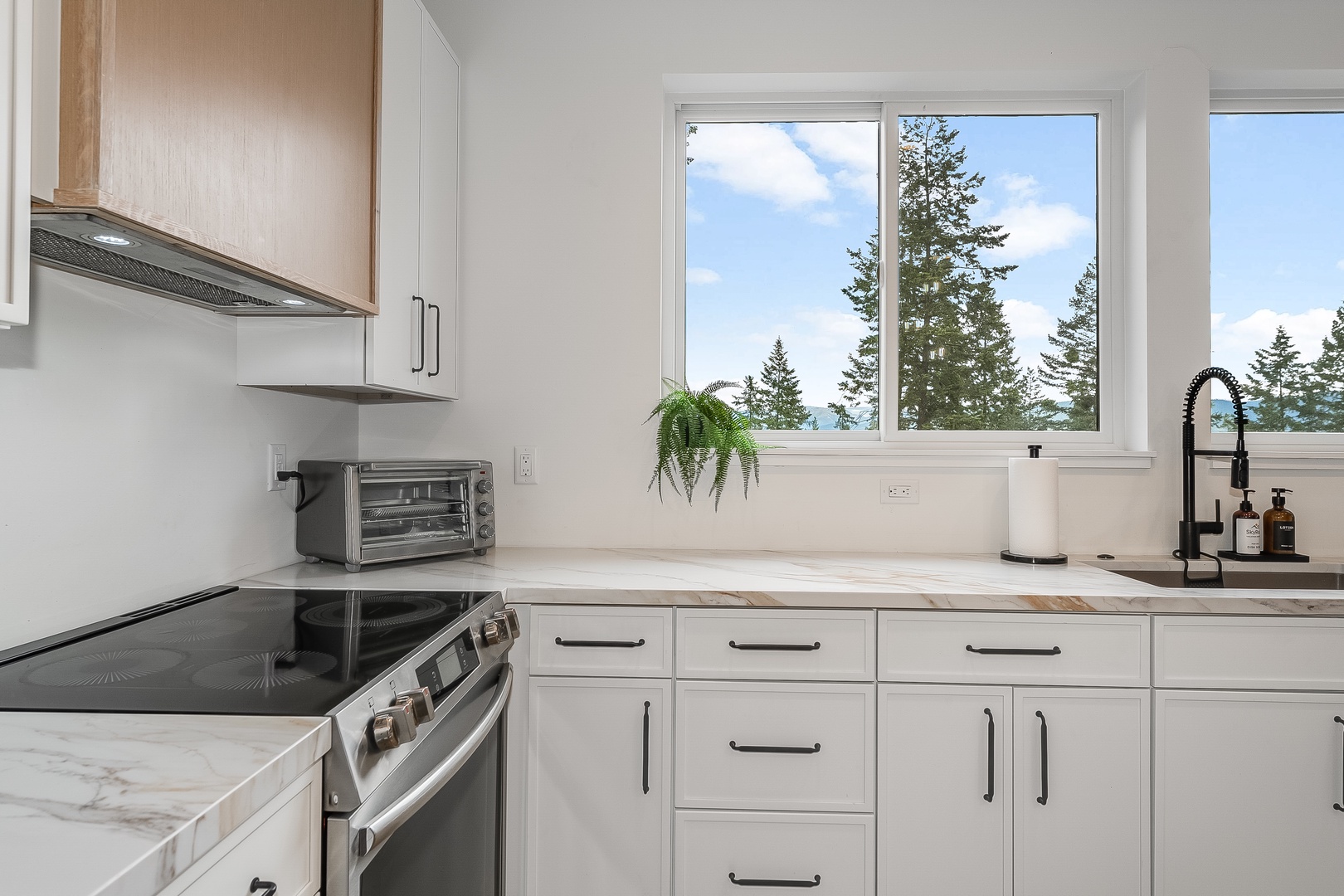 You'll love cooking in this bright, modern kitchen with serene treetop views. Clean counters and plenty of storage make meal prep a breeze while you enjoy the natural light streaming through the window.