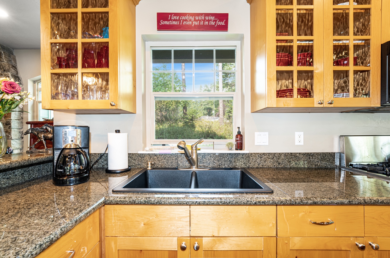 Your kitchen features granite counters, ample cabinetry, and a charming window overlooking tranquil greenery—perfect for sipping morning coffee while enjoying nature's calm right from the sink.