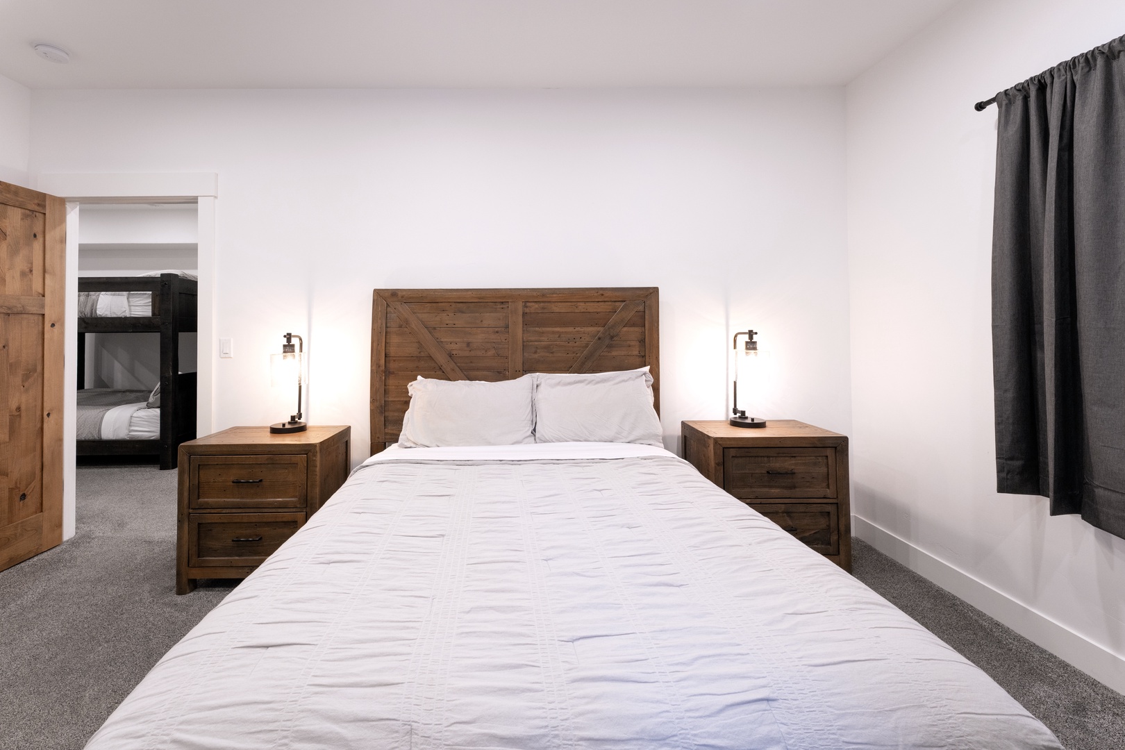 Sink into crisp white linens and rustic wood charm in your peaceful bedroom retreat, complete with modern conveniences.