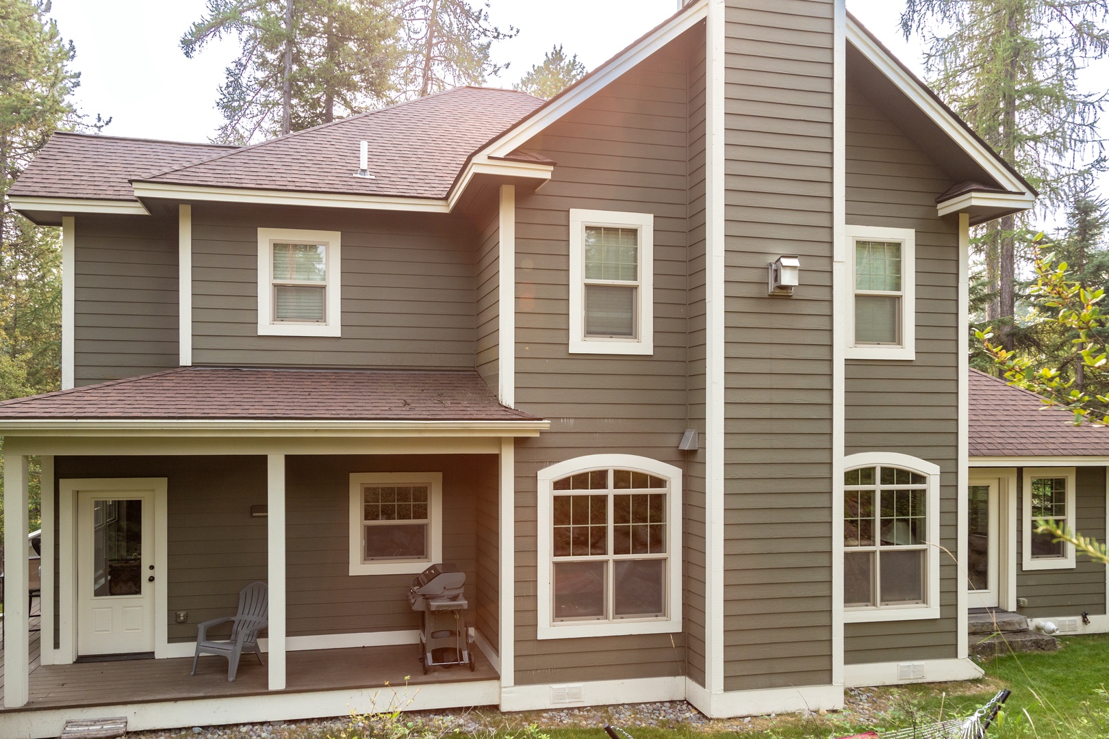 A charming two-story cabin nestled among towering trees, offering a peaceful woodland setting for your getaway. The covered porch provides a perfect spot to relax and enjoy the serene natural surroundings.