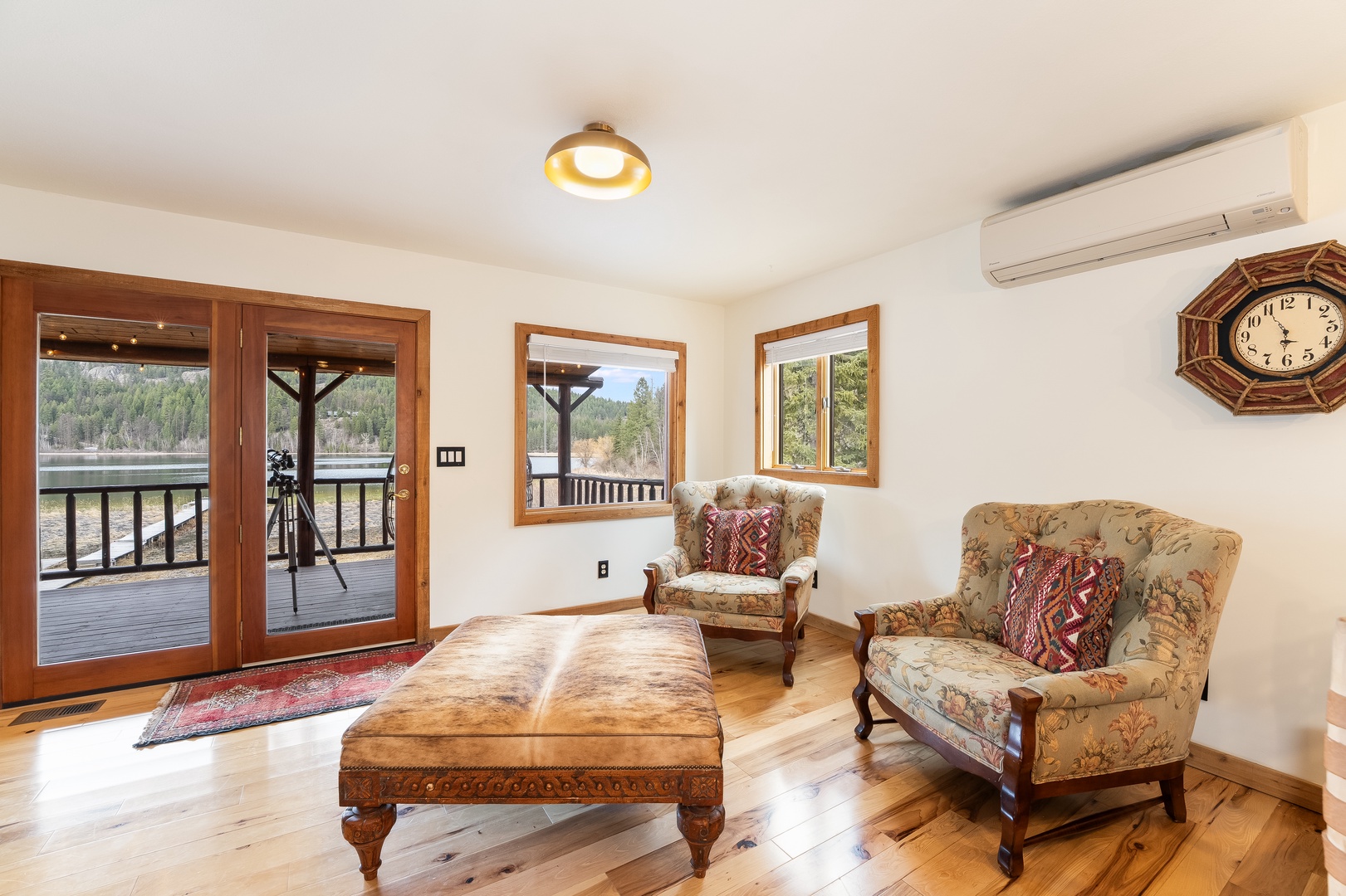 Unwind in your cozy living room with handcrafted furnishings and French doors opening to a private deck overlooking serene waters.