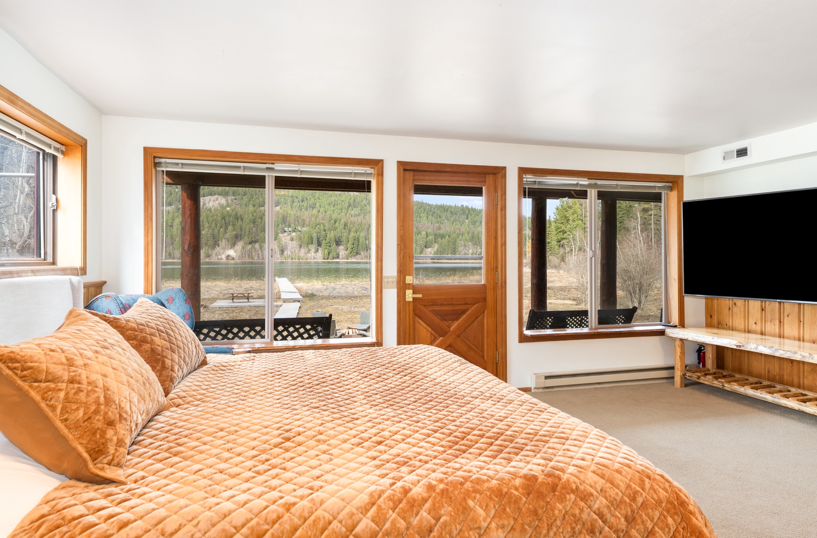Wake up to stunning lake and mountain views from your spacious bedroom, where warm wood touches create the perfect retreat.