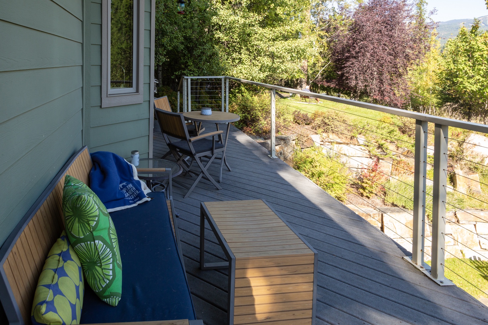 Relax on your private deck surrounded by mountain views and lush greenery—perfect for sipping morning coffee or unwinding after a day of adventure, with comfortable seating and peaceful natural scenery all around.