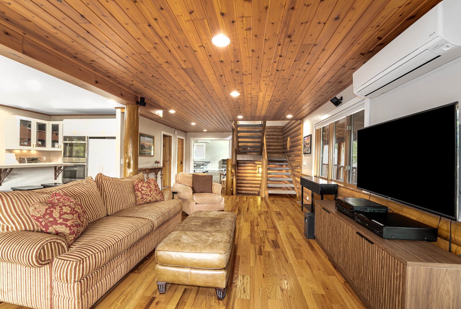 Unwind in your spacious living area with stunning wood-plank ceilings, plush seating, and modern entertainment. The open layout connects effortlessly to the kitchen—perfect for relaxing or gathering with loved ones.
