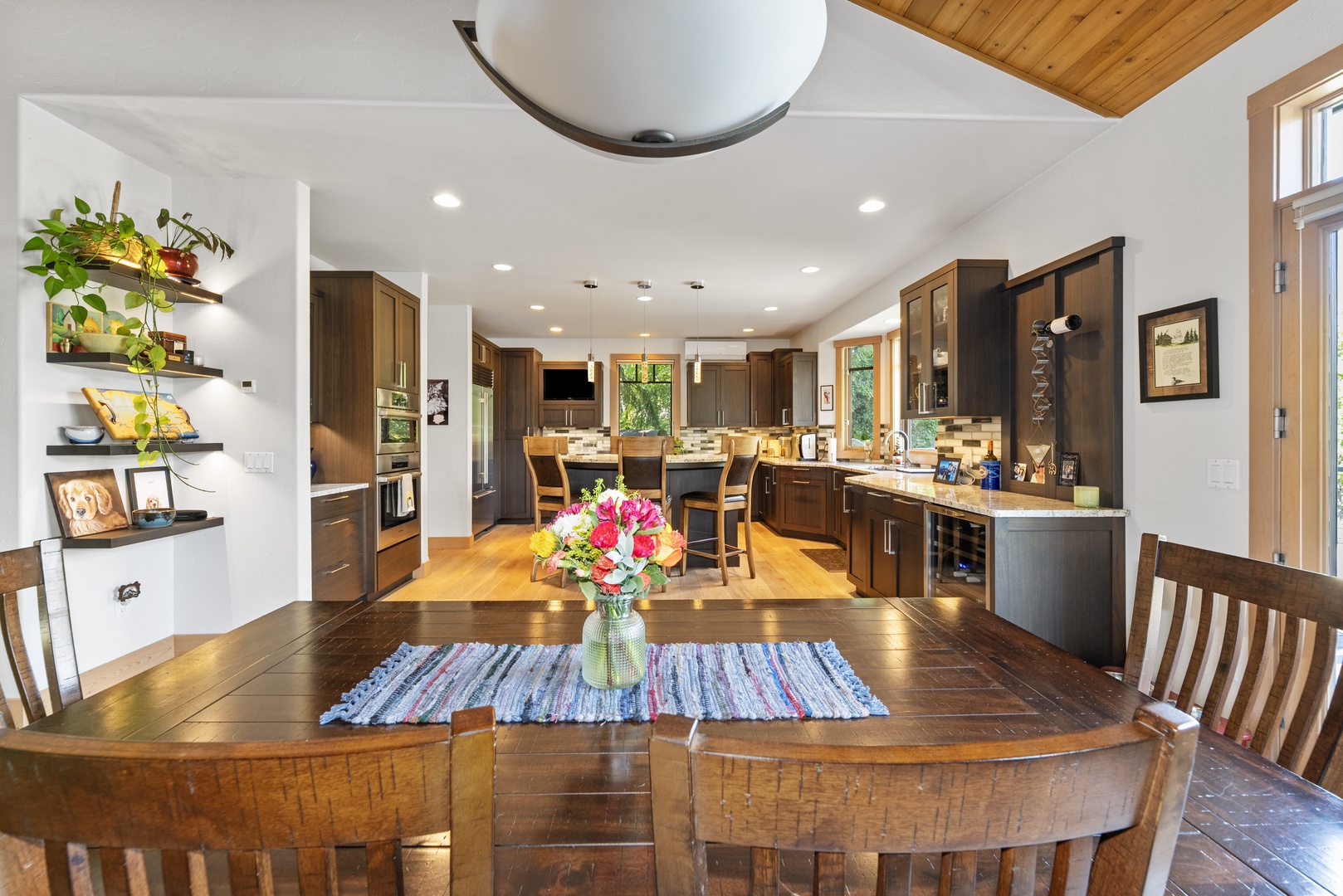 Step into your spacious open-concept kitchen and dining area, where warm wood tones and abundant natural light create an inviting space for gathering and making memories together.