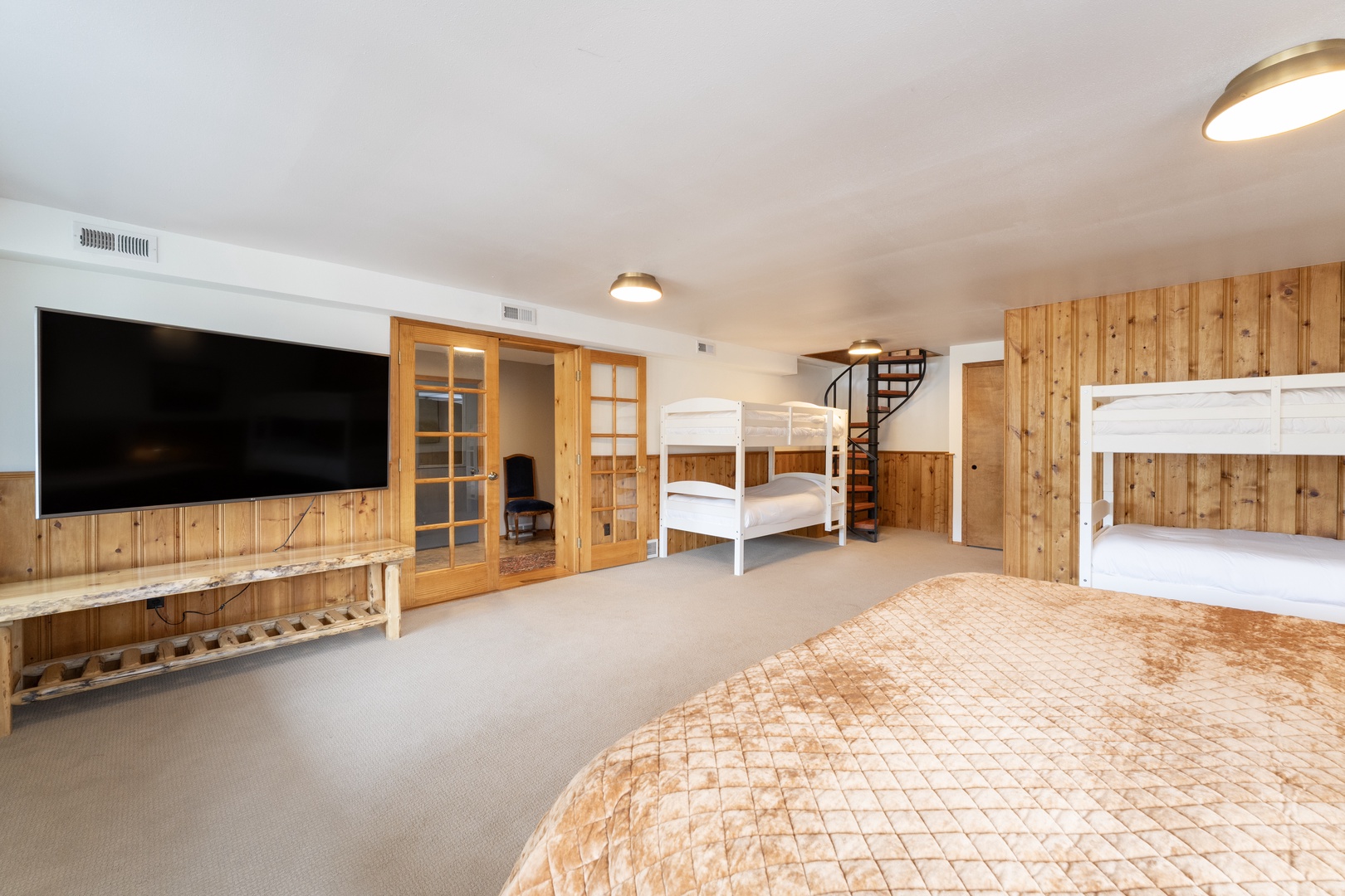 Your spacious bedroom features cozy bunk beds and a large TV for family movie nights in rustic comfort.