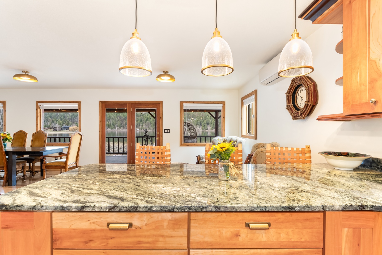 Cook and connect in your open kitchen featuring granite counters, warm wood cabinetry, and pendant lighting that flows into the dining area.