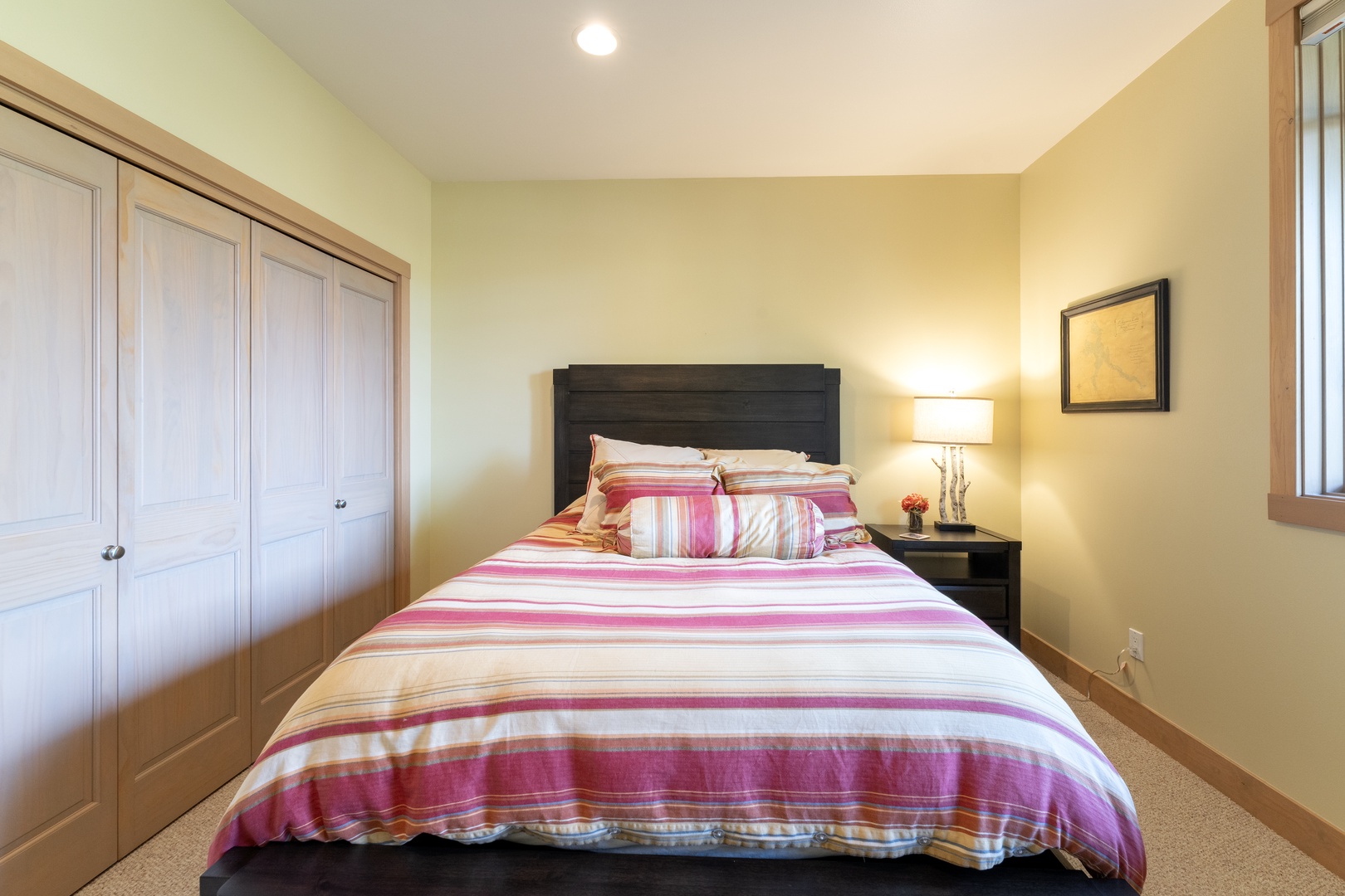 Slip into this cozy bedroom where soft lighting and cheerful striped linens invite you to unwind after a day of exploring. Ample closet space keeps your belongings organized and out of sight.