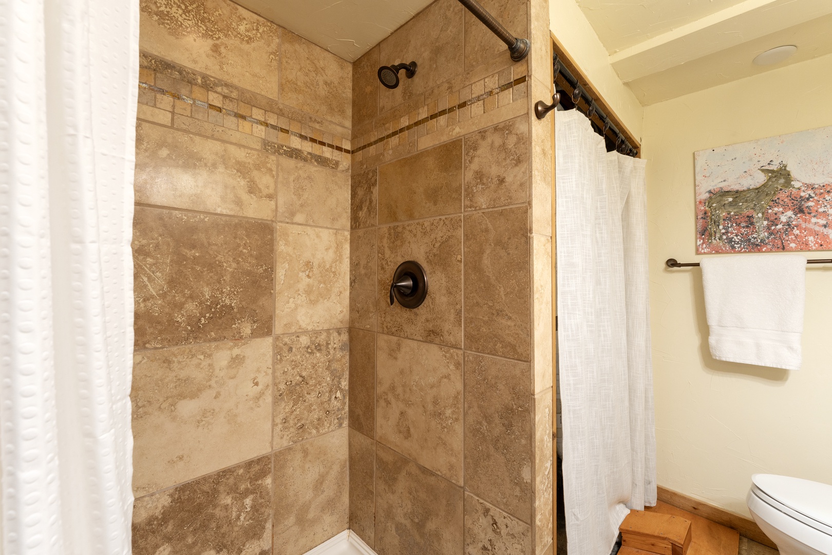 Step into your private spa-like shower featuring beautiful travertine tiles and rainfall showerhead for the perfect unwind.