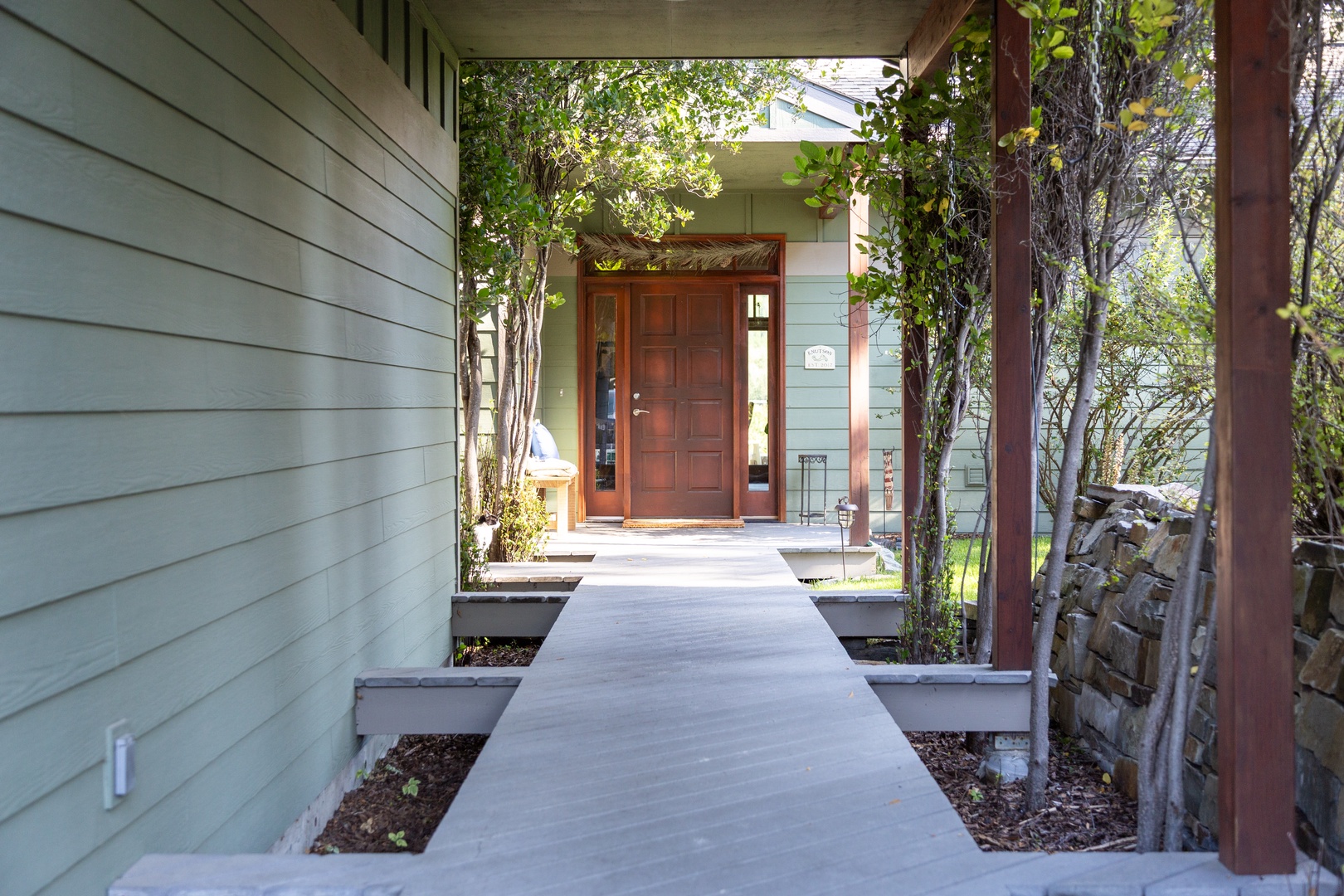 The welcoming entrance pathway leads through a peaceful, tree-lined setting to your private retreat, where nature and comfort meet at your doorstep.