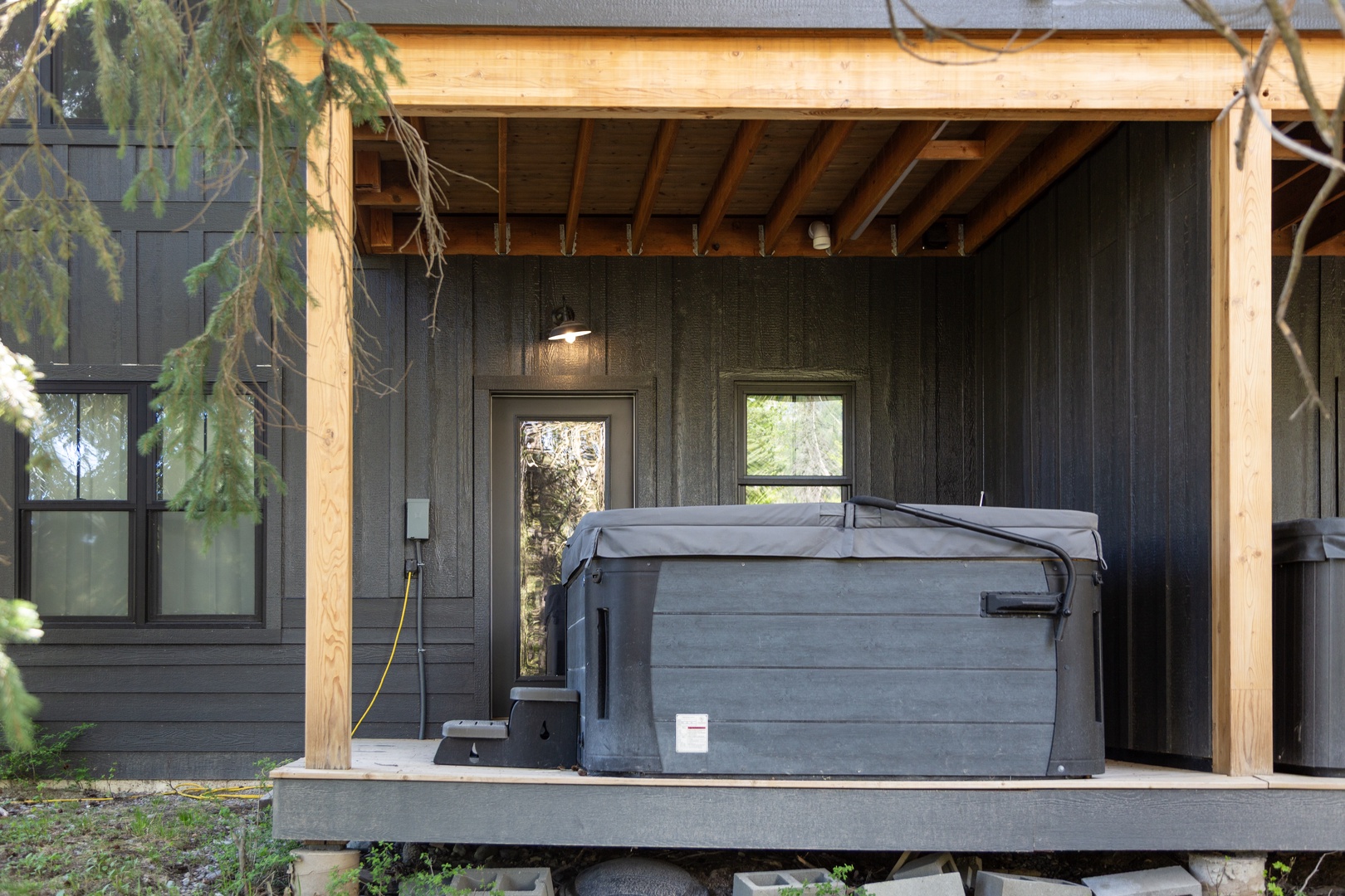 Sheltered outdoor hot tub with natural wood accents and private views of surrounding greenery offers a secluded spot to unwind after exploring the area.