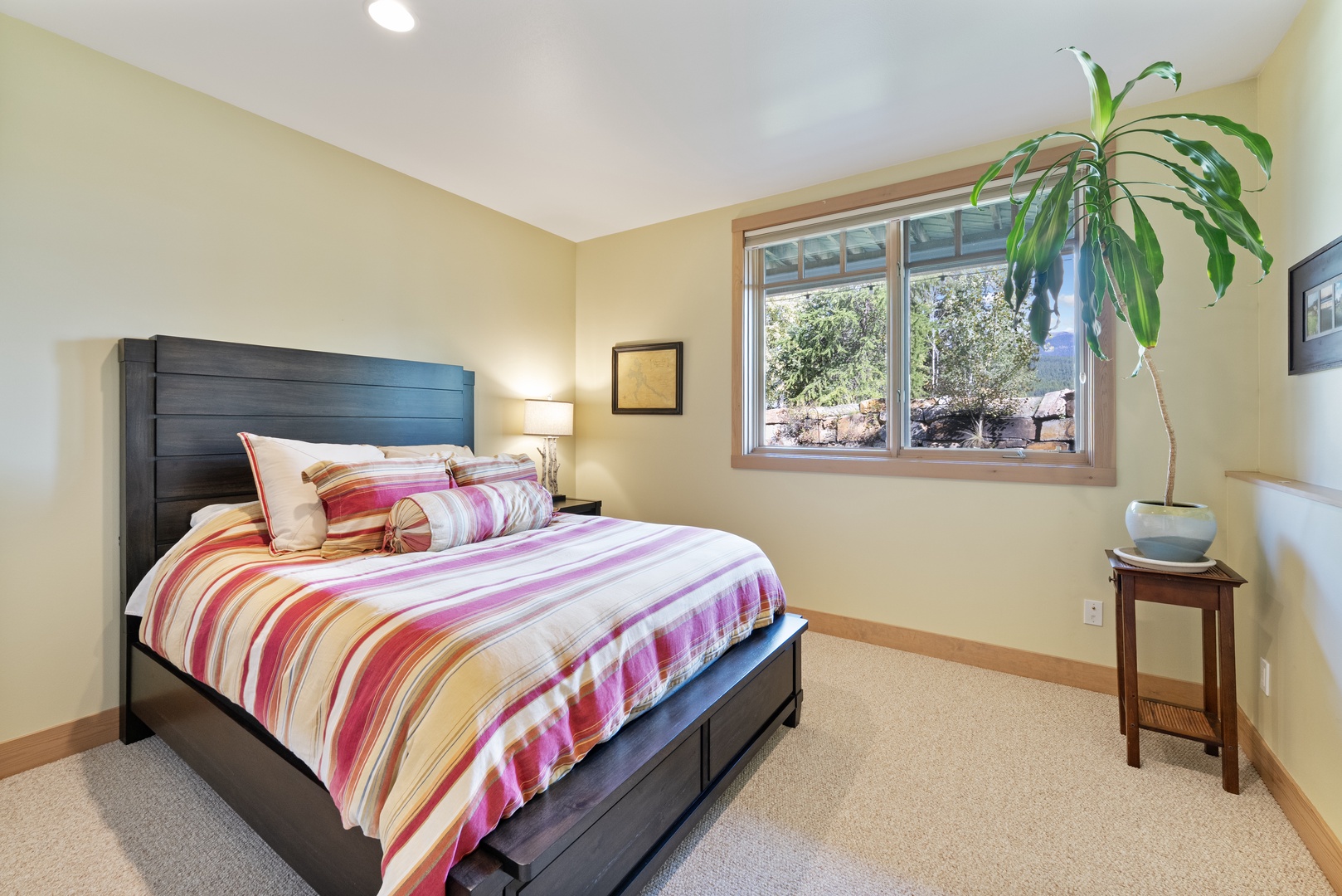 Unwind in your cheerful bedroom, where warm yellow walls and soft natural light create a welcoming cocoon. Colorful striped bedding adds a playful touch, while the garden view reminds you nature is just outside.