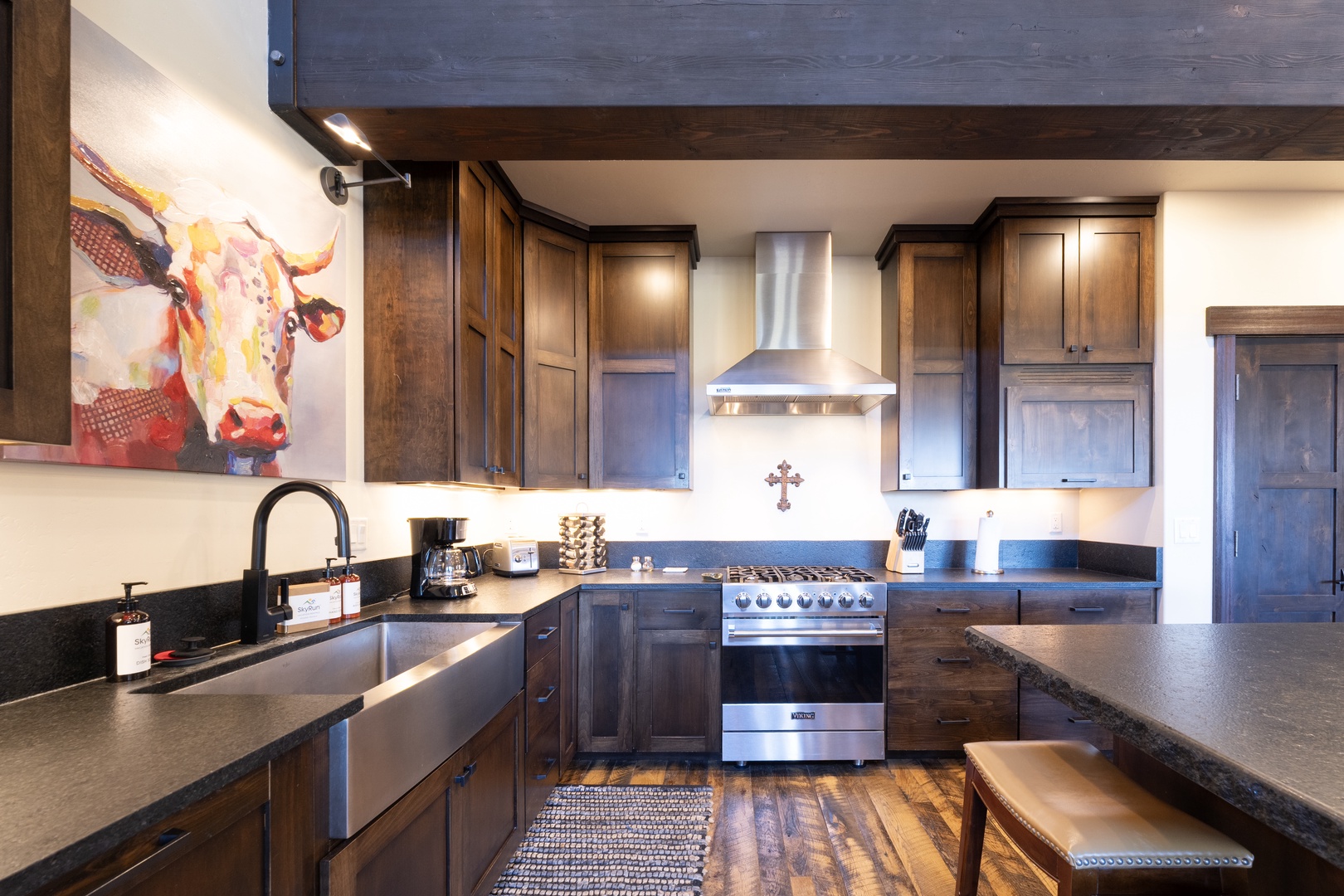 Your gourmet kitchen blends rustic charm with modern convenience, featuring rich wood cabinetry, sleek granite countertops, and professional-grade appliances perfect for preparing memorable meals during your stay.