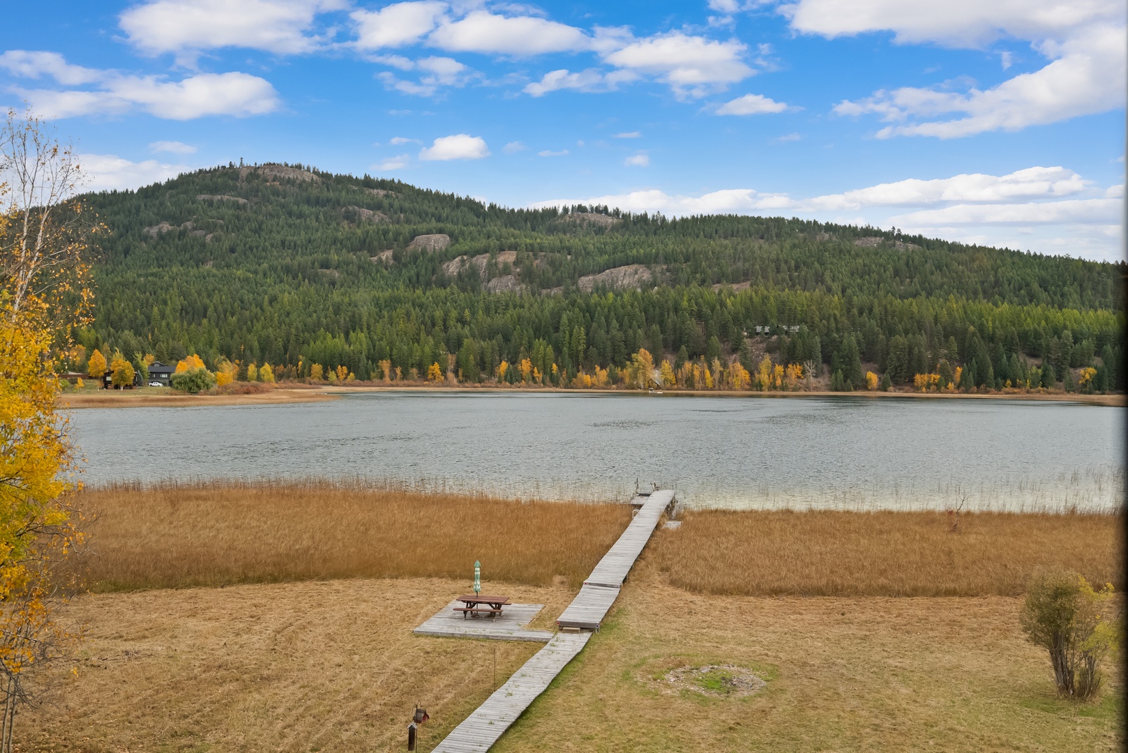 Scenic lake view with peaceful waters, autumn foliage, and forested mountains creating a tranquil natural setting.