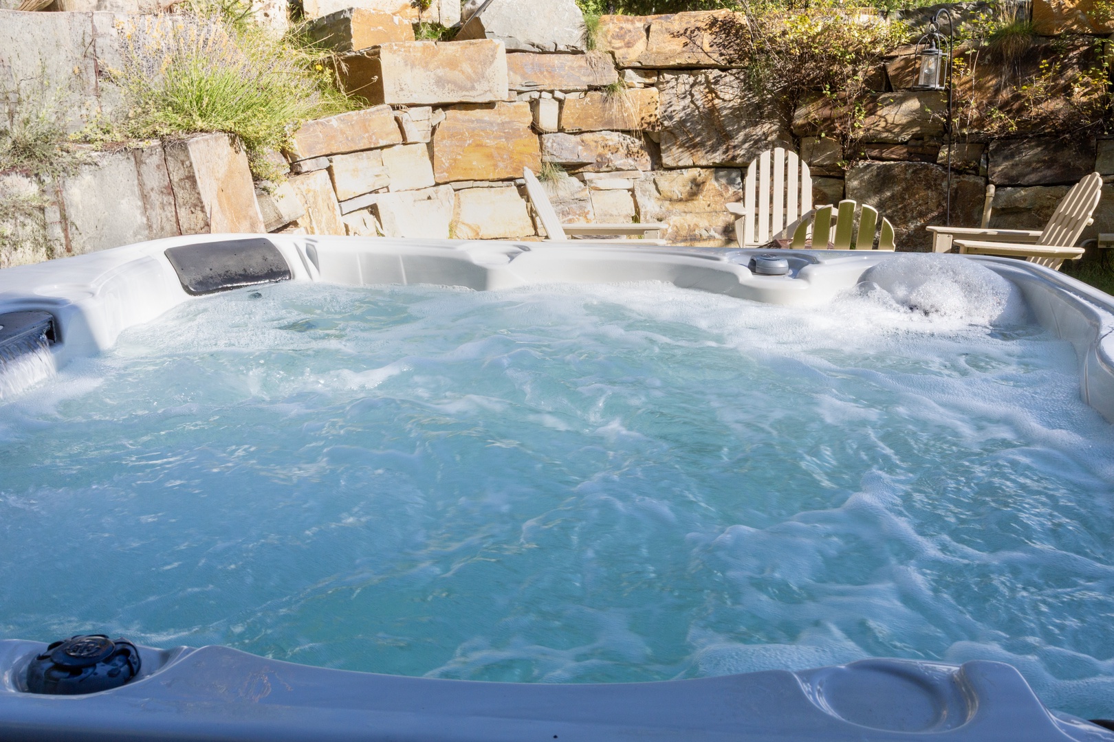 Slip into your private hot tub, surrounded by natural stone and soft landscaping—the perfect place to unwind under open skies.