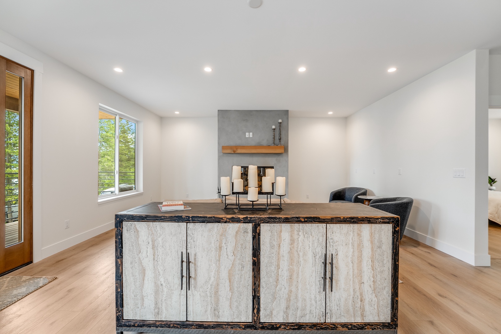 Your spacious dining area blends rustic charm with modern elegance. Natural light streams through large windows, highlighting the unique live-edge table and stylish storage—perfect for memorable meals and gatherings.