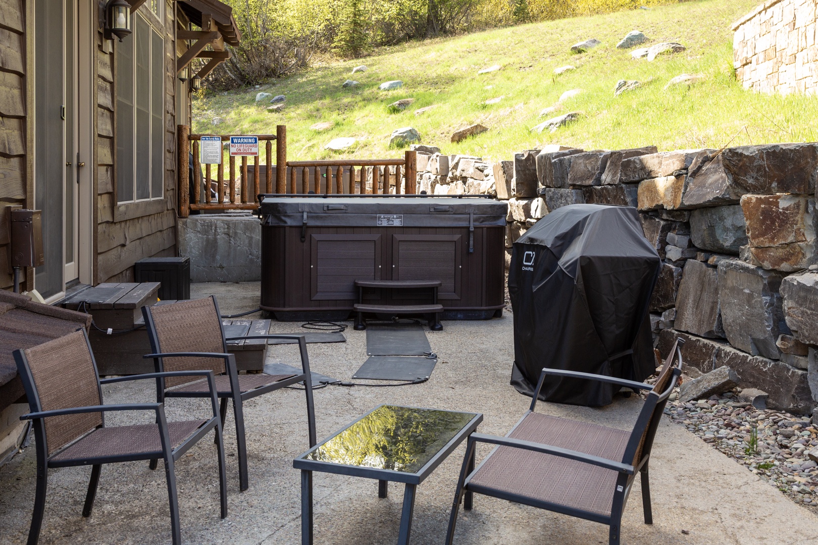 Unwind in your private patio featuring a hot tub, BBQ grill, and comfortable seating—perfect for relaxing after exploring the mountains.