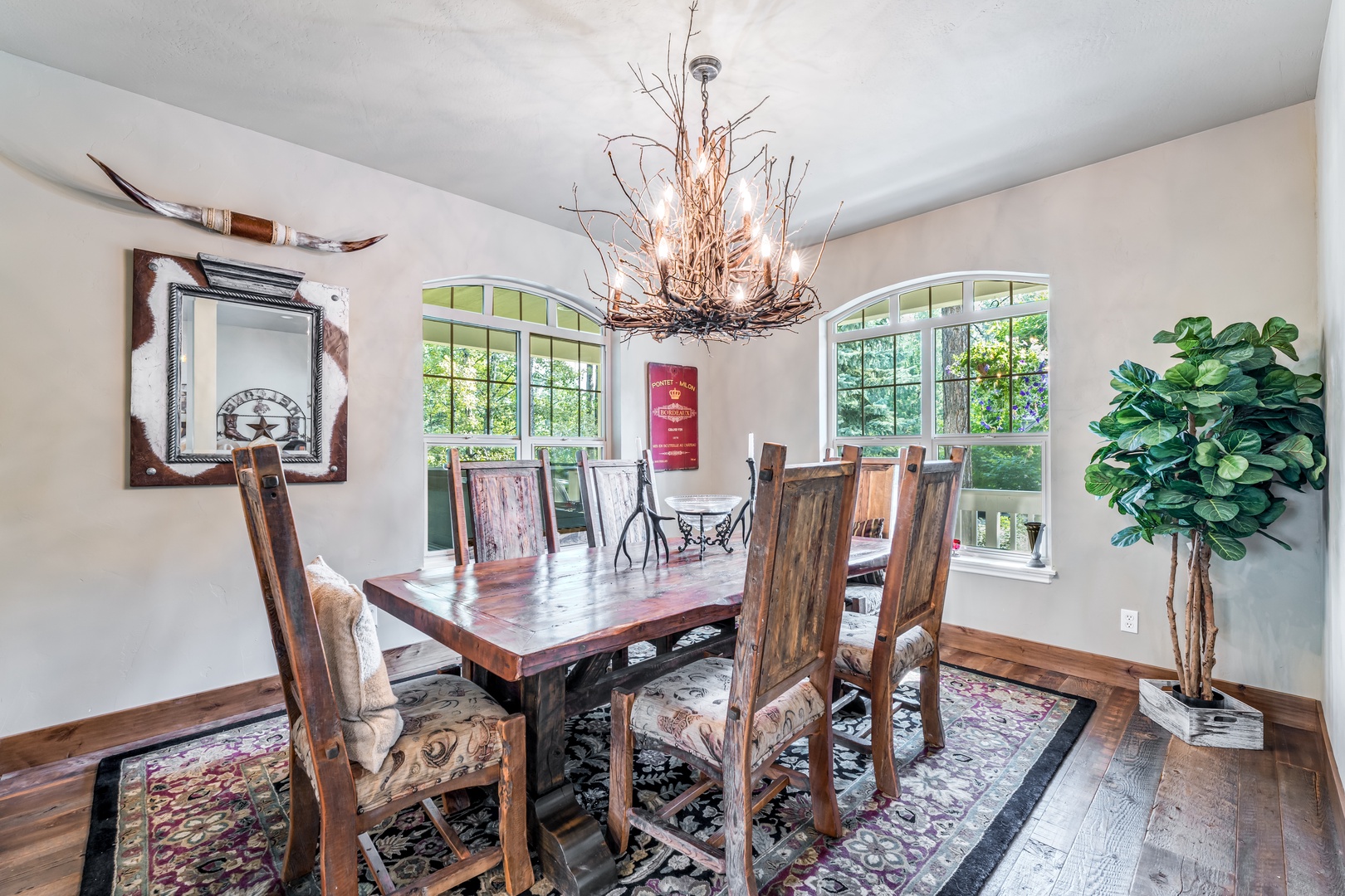 This bright dining area welcomes you with rustic charm and custom touches. The unique chandelier and handcrafted table create a warm, inviting space for your memorable meals together.