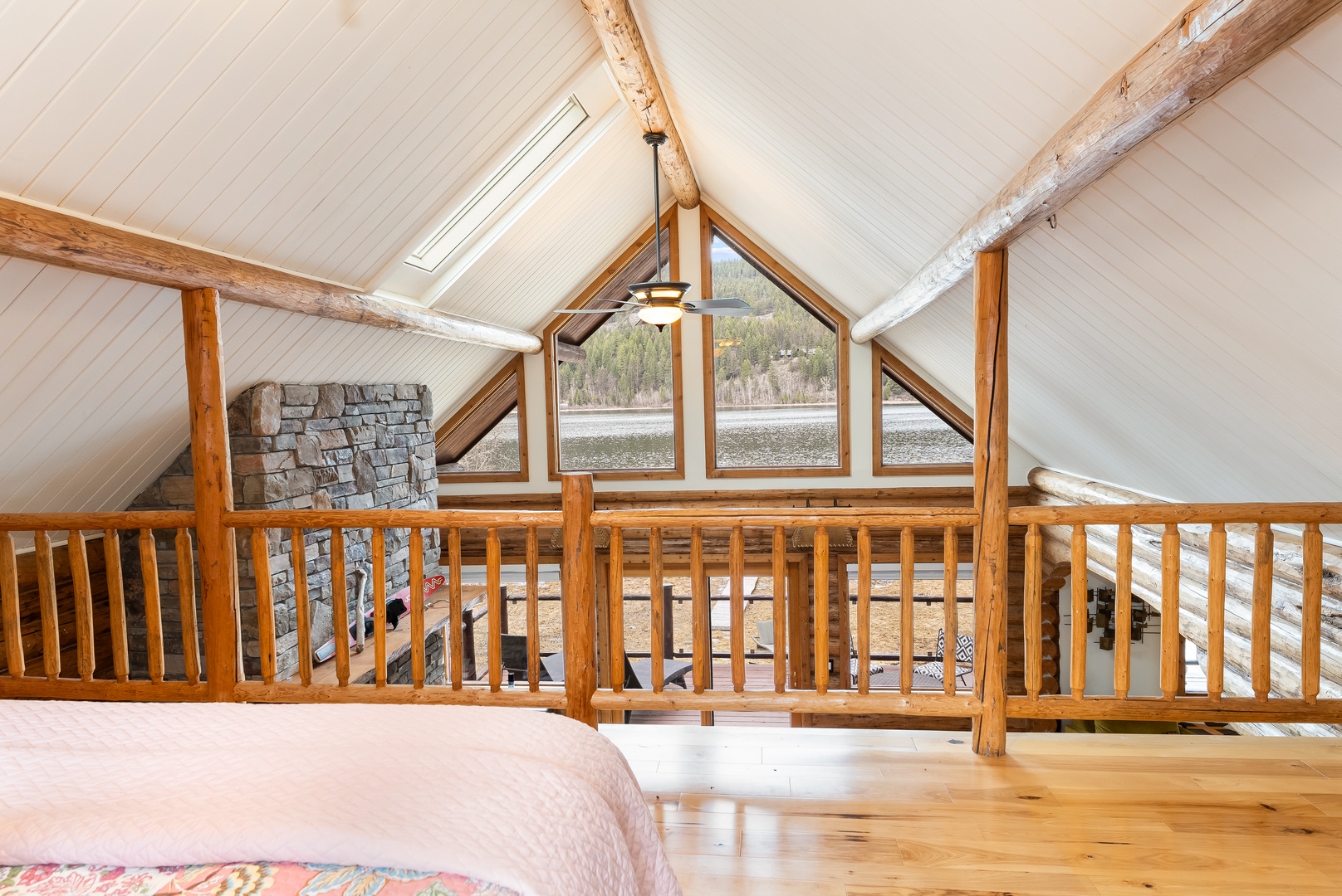 Wake up in your cozy loft bedroom with stunning lake views framed by rustic beams and natural light streaming through skylights.