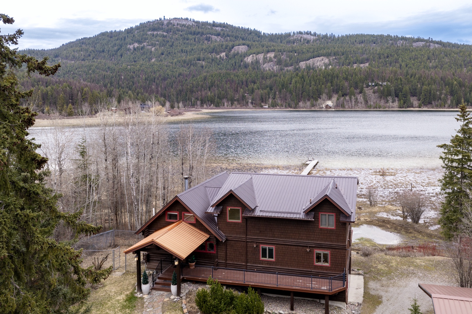 Stunning mountain lakefront property featuring expansive forest views and peaceful waterfront setting.