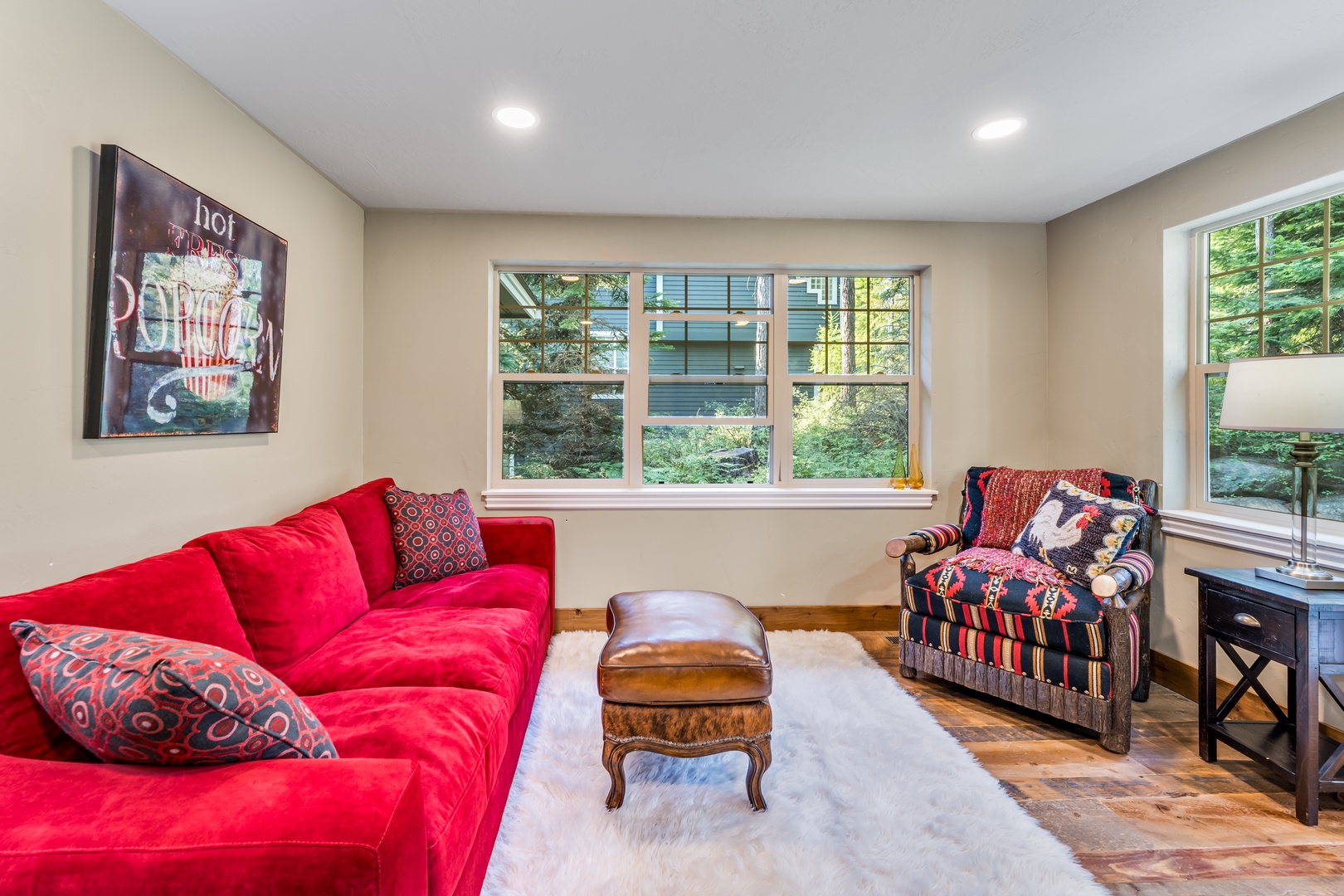 Curl up with a book in your own cheerful sitting room, where vibrant red seating, plush textures, and peaceful garden views create the perfect escape for quiet moments or lively conversation.