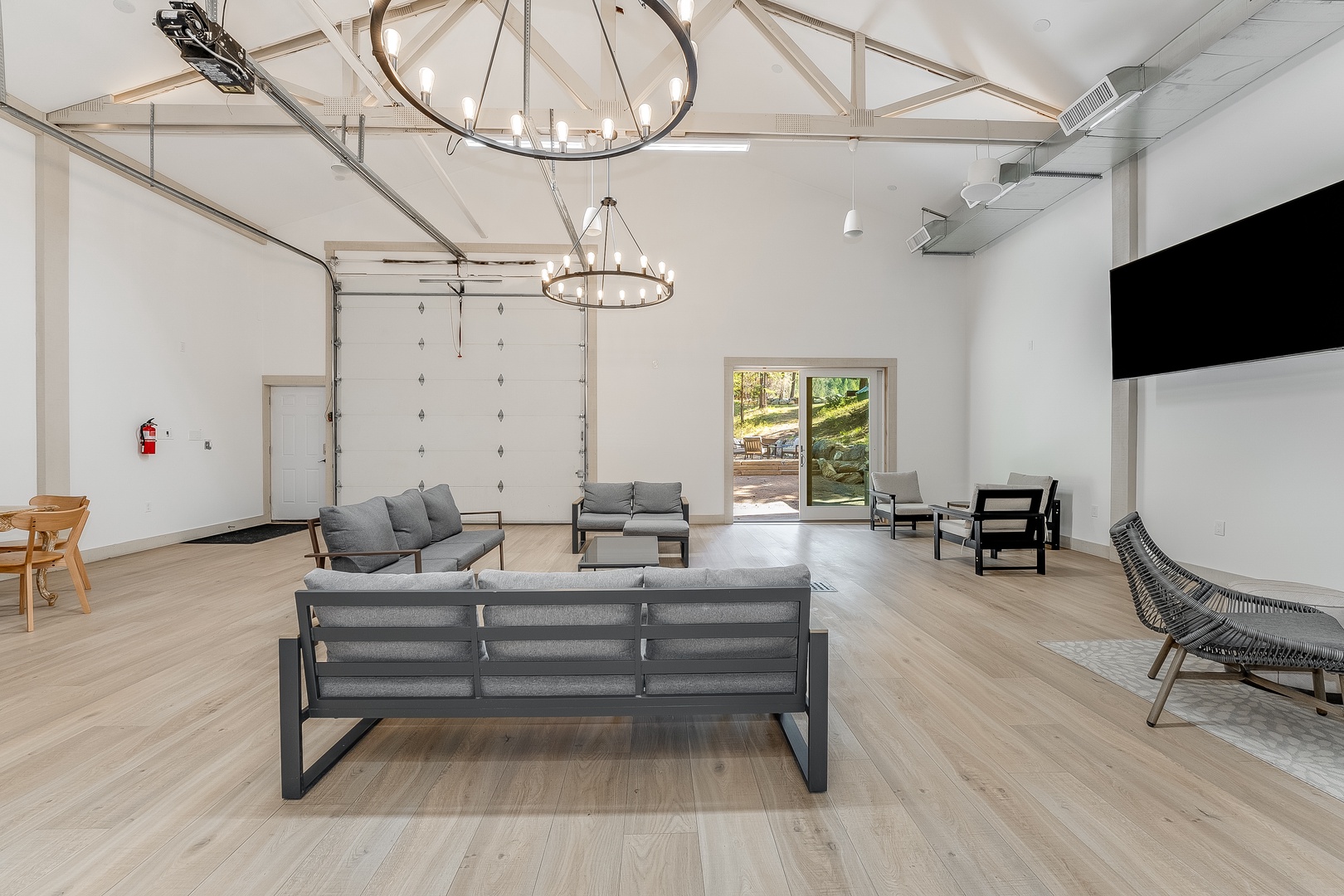 Step into your spacious communal lounge—soaring vaulted ceilings, airy light wood floors, and sleek modern seating create an inviting space where you can relax or socialize.