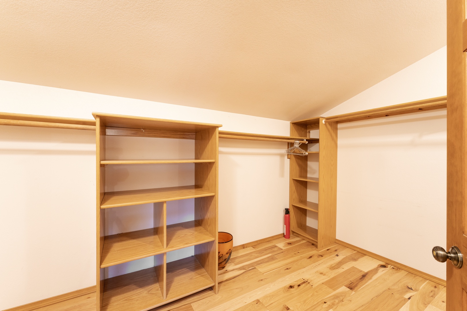 Your private walk-in closet offers abundant storage with custom wooden shelving and hanging space for all your belongings.