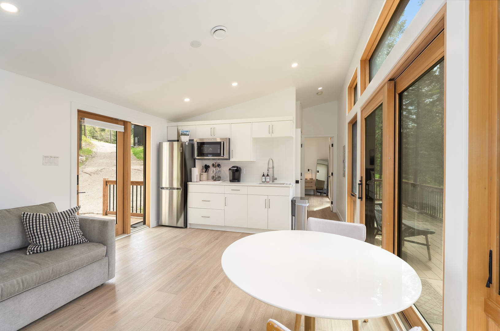Unwind in your bright, airy open-plan living space where natural light floods through floor-to-ceiling windows, inviting you to relax on the plush sofa or step onto your private balcony.